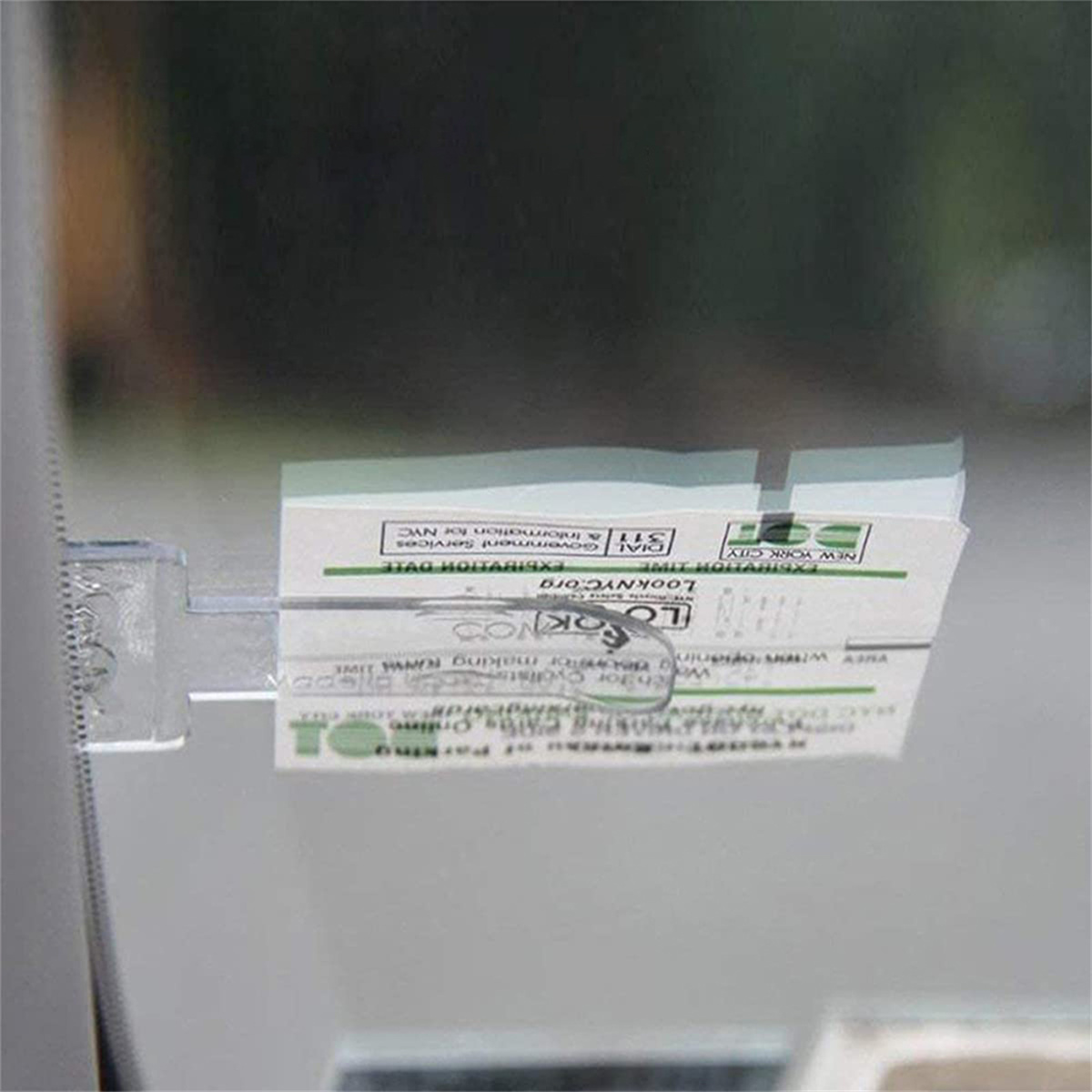 Ein Parkticket ist an der Autoscheibe befestigt. Das Ticket hat Text und Logos. Der Hintergrund ist unscharf.