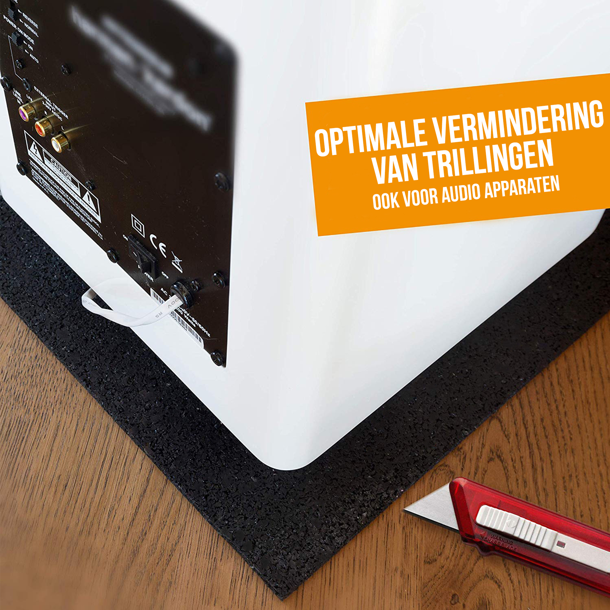 Un haut-parleur blanc est posé sur un tapis noir texturé, avec un cutter visible. Texte : 'Réduction optimale des vibrations'.