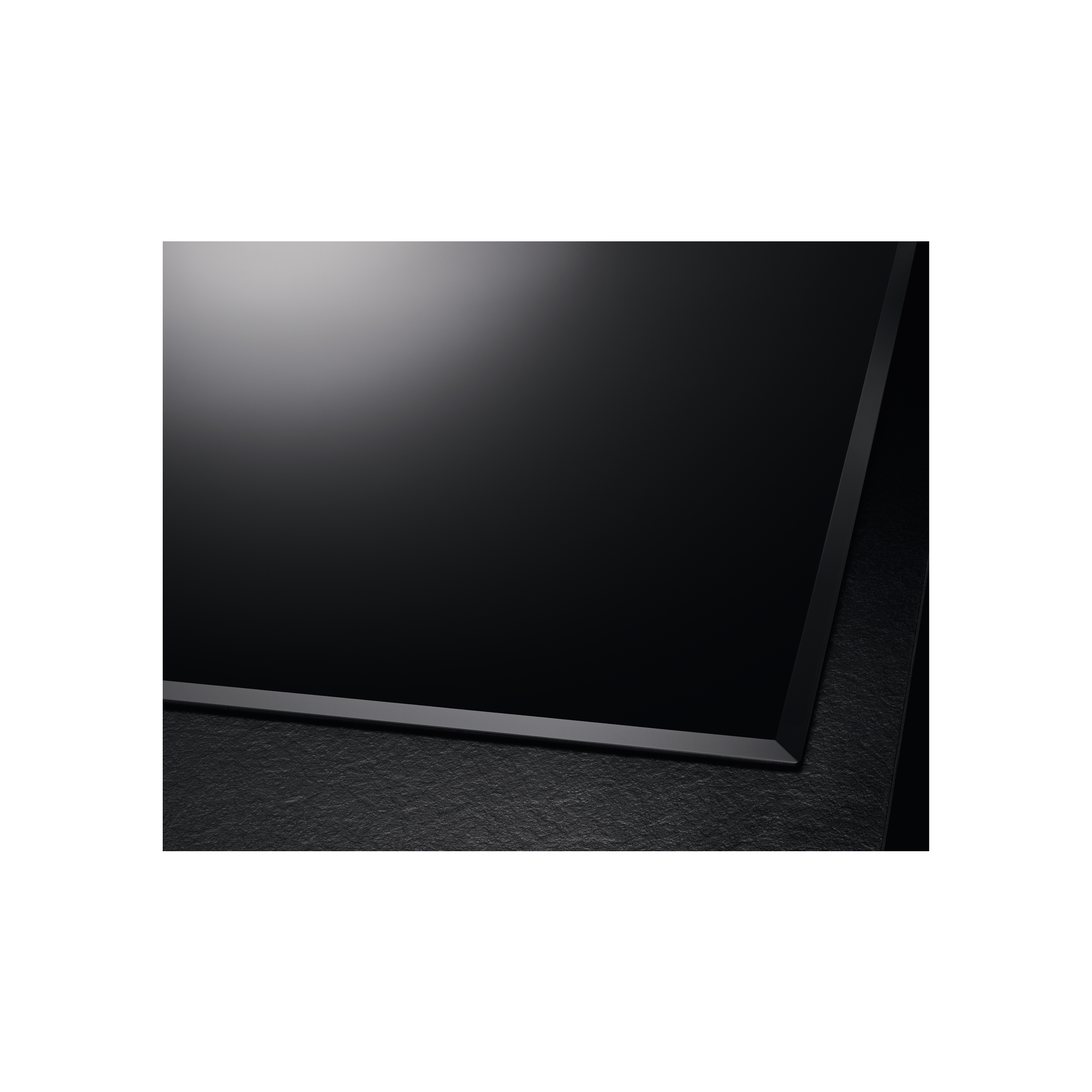 Primo piano di un piano cottura a induzione nero dal design elegante, con superficie e bordo scuri.