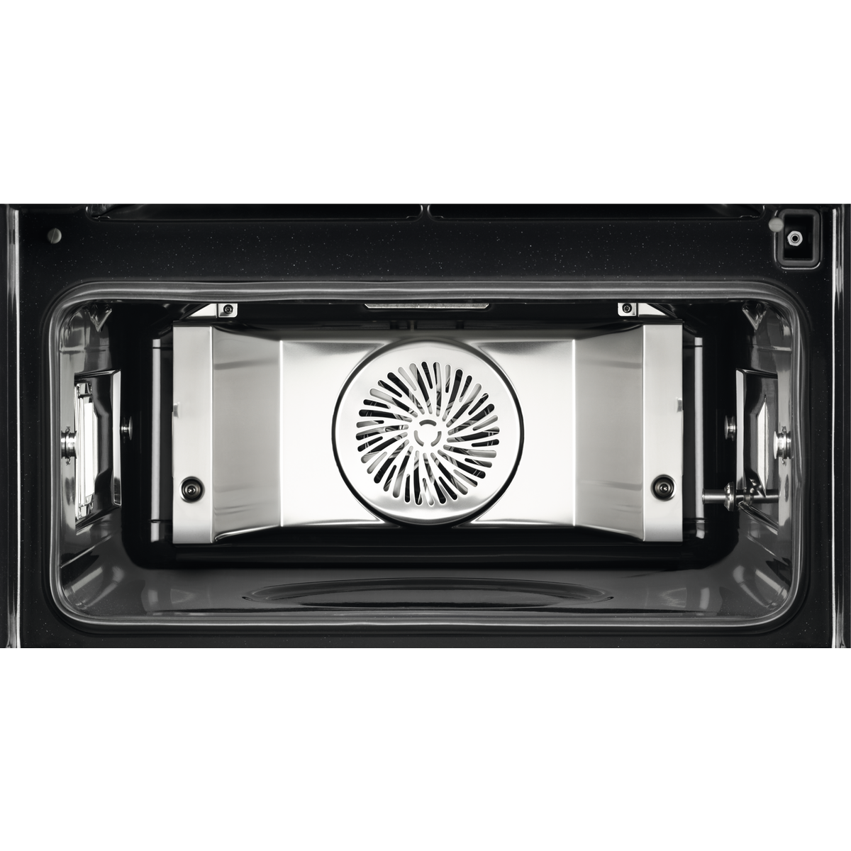 El interior de un horno con un ventilador y componentes metálicos.