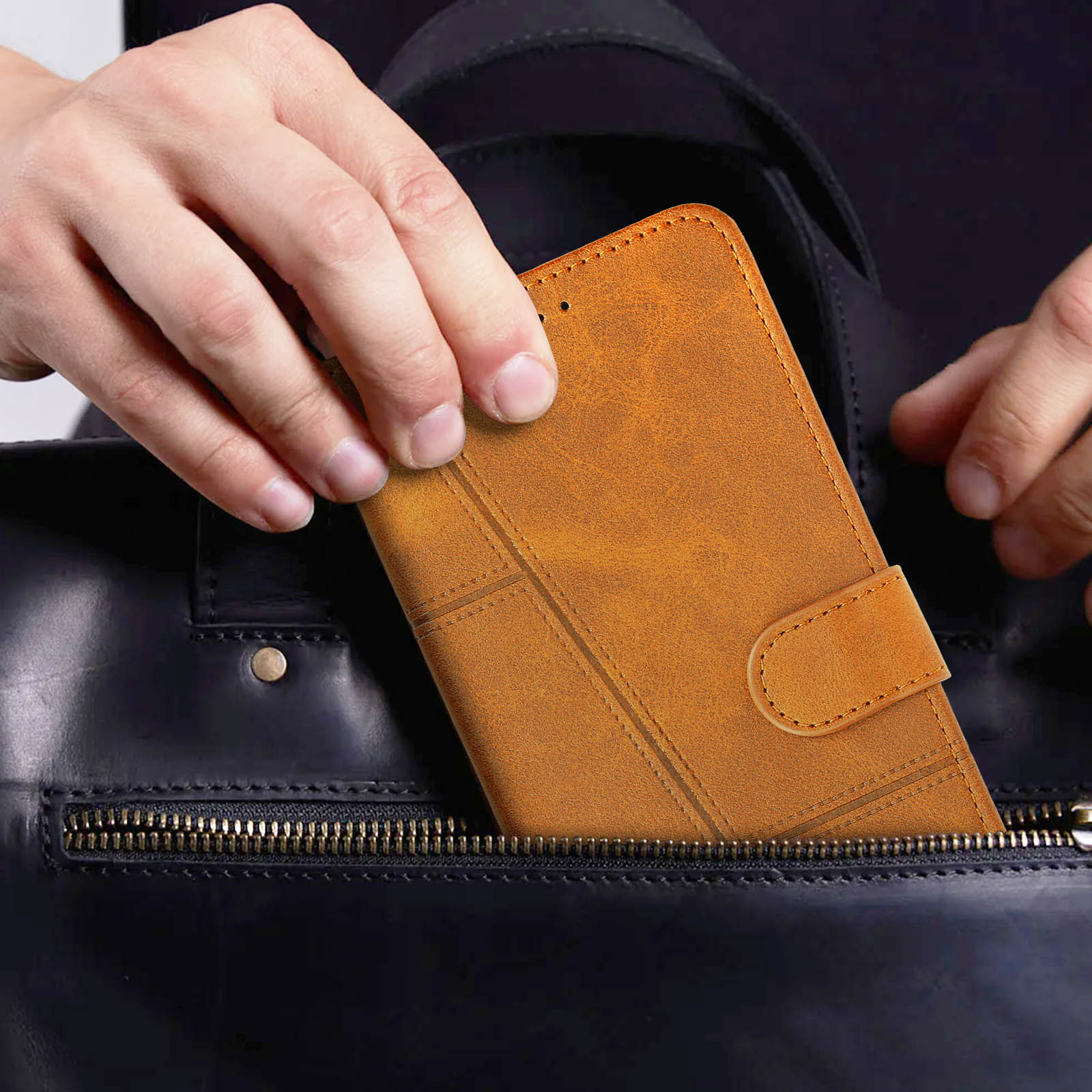 Hände halten braune Leder-Handyhülle, geöffnet, in einer schwarzen Tasche.