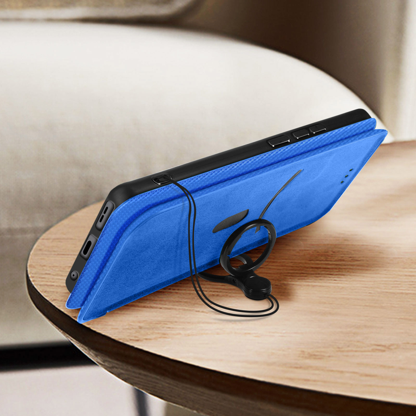 Un telefono con custodia blu su un tavolo di legno con un supporto ad anello.