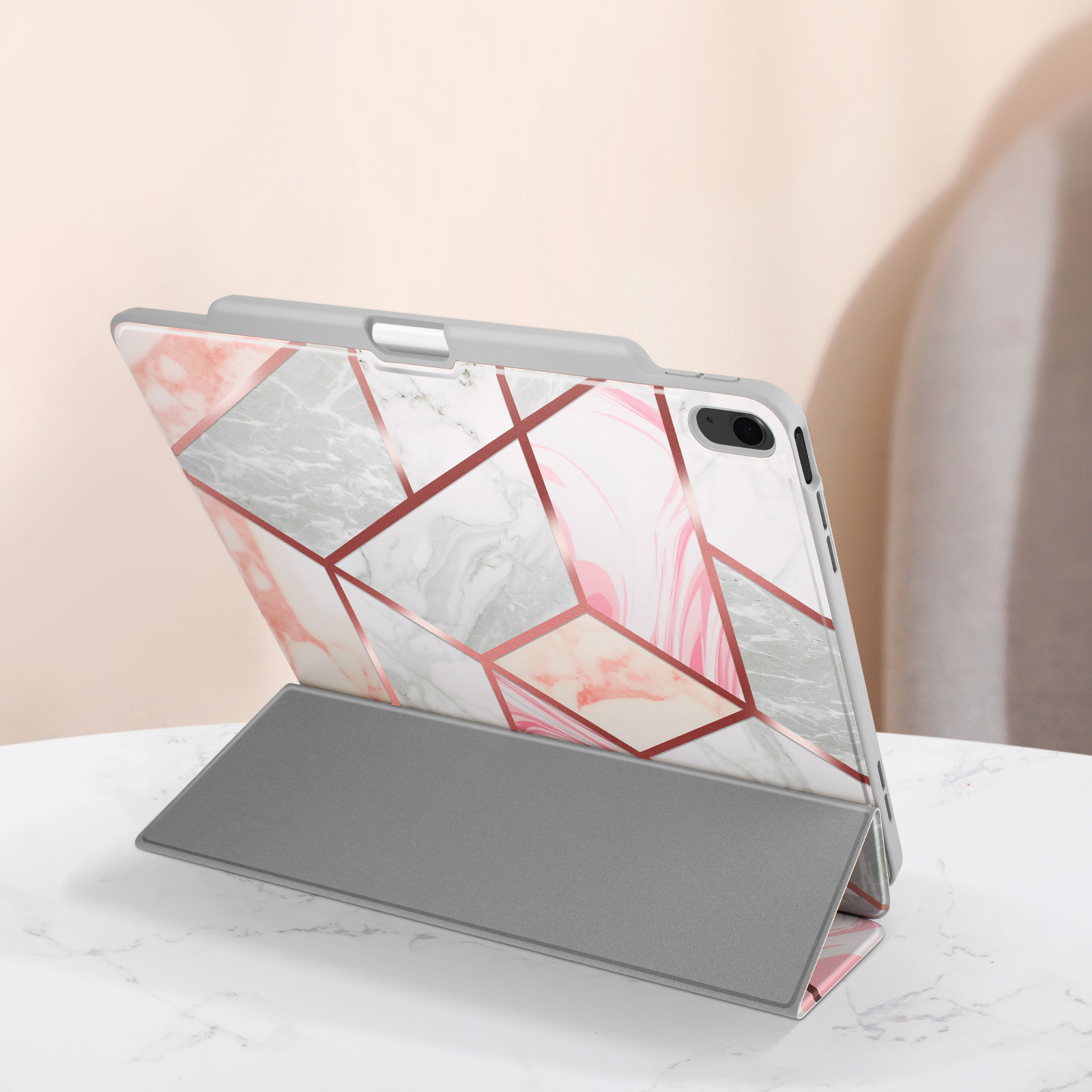 Una custodia grigia per tablet con un design marmorizzato e un supporto integrato.