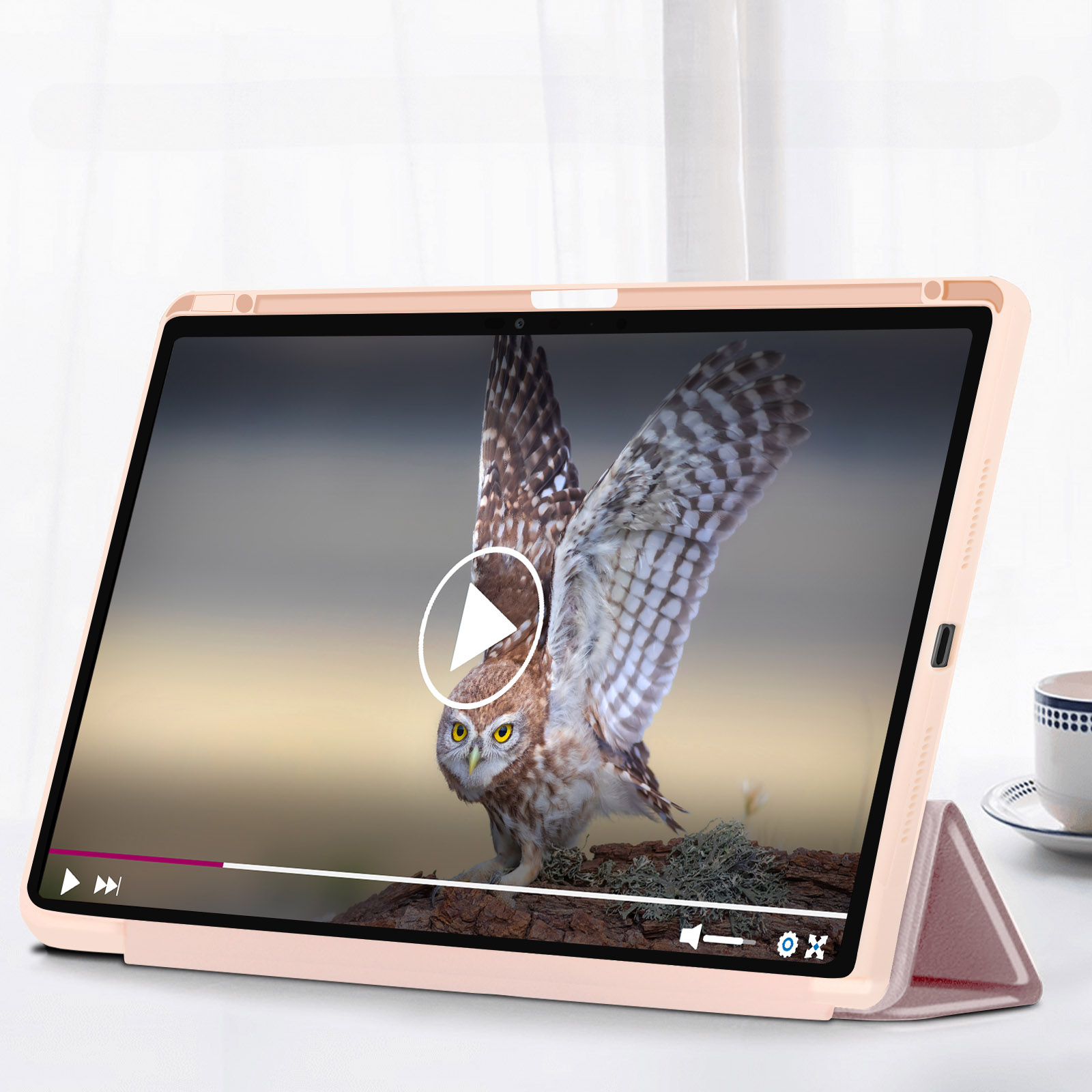Lo schermo di un tablet mostra un video di un gufo. Il tablet è in una custodia rosa appoggiata su un tavolo.