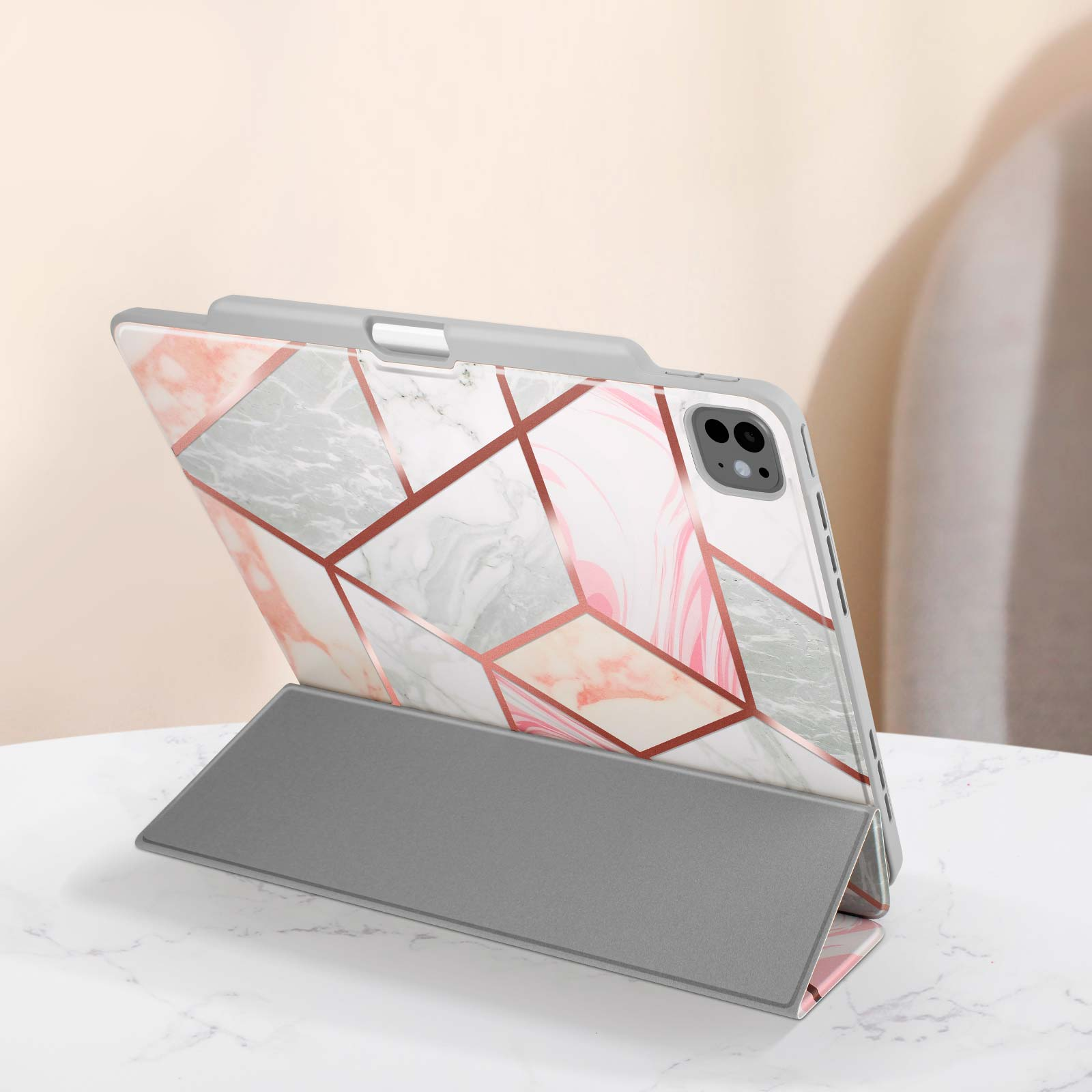 Tablet in un supporto con design marmorizzato e cornice grigia. Anche il supporto è grigio.
