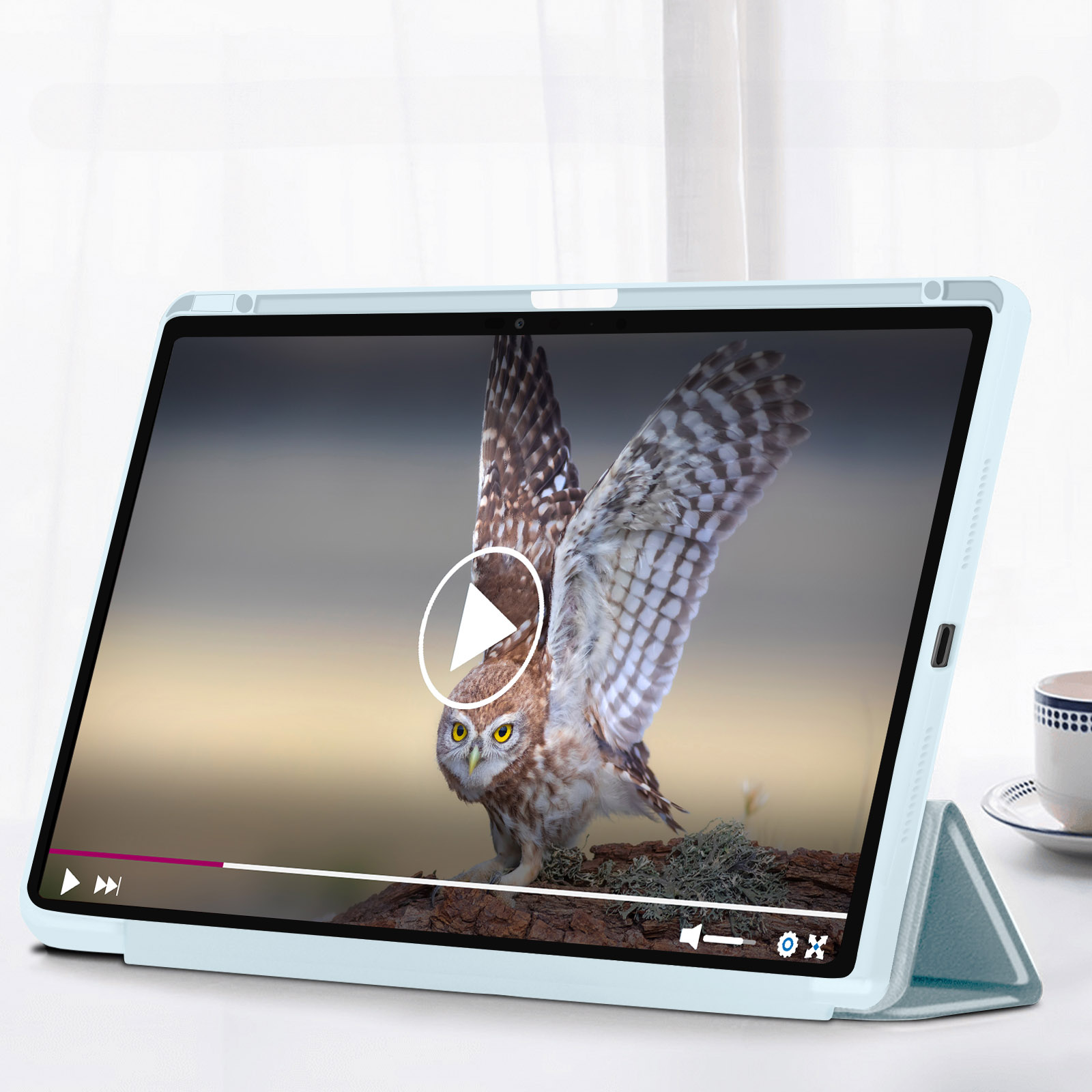 Tablet che mostra un video di gufo con controlli, su un tavolo bianco.