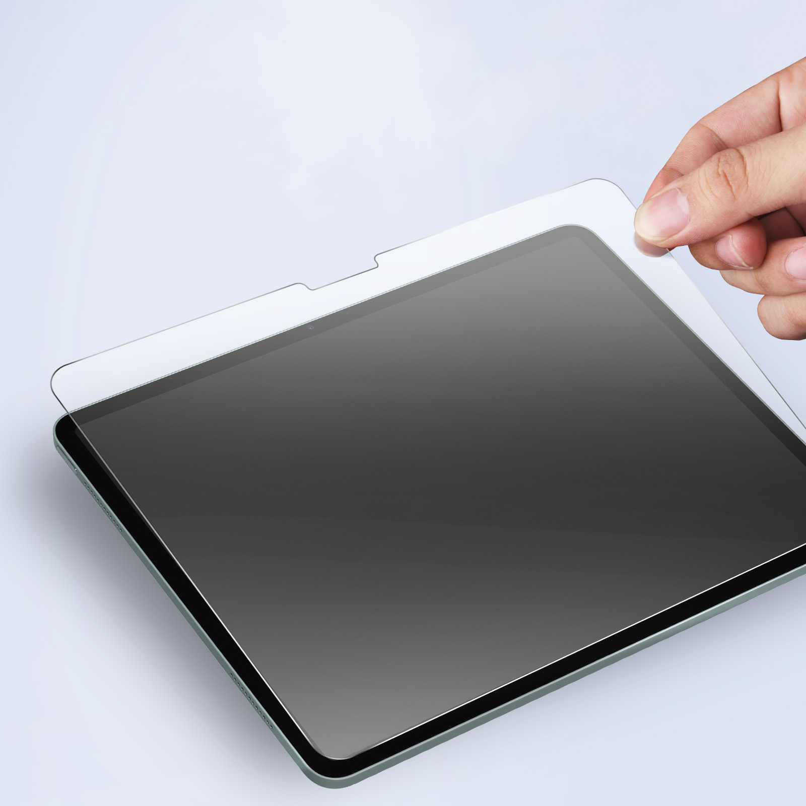 Main plaçant un protecteur d'écran sur une tablette.