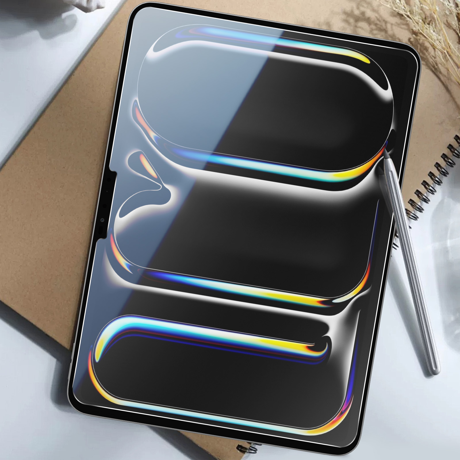 Tablet con schermo lucido, stilo e taccuino su una scrivania.