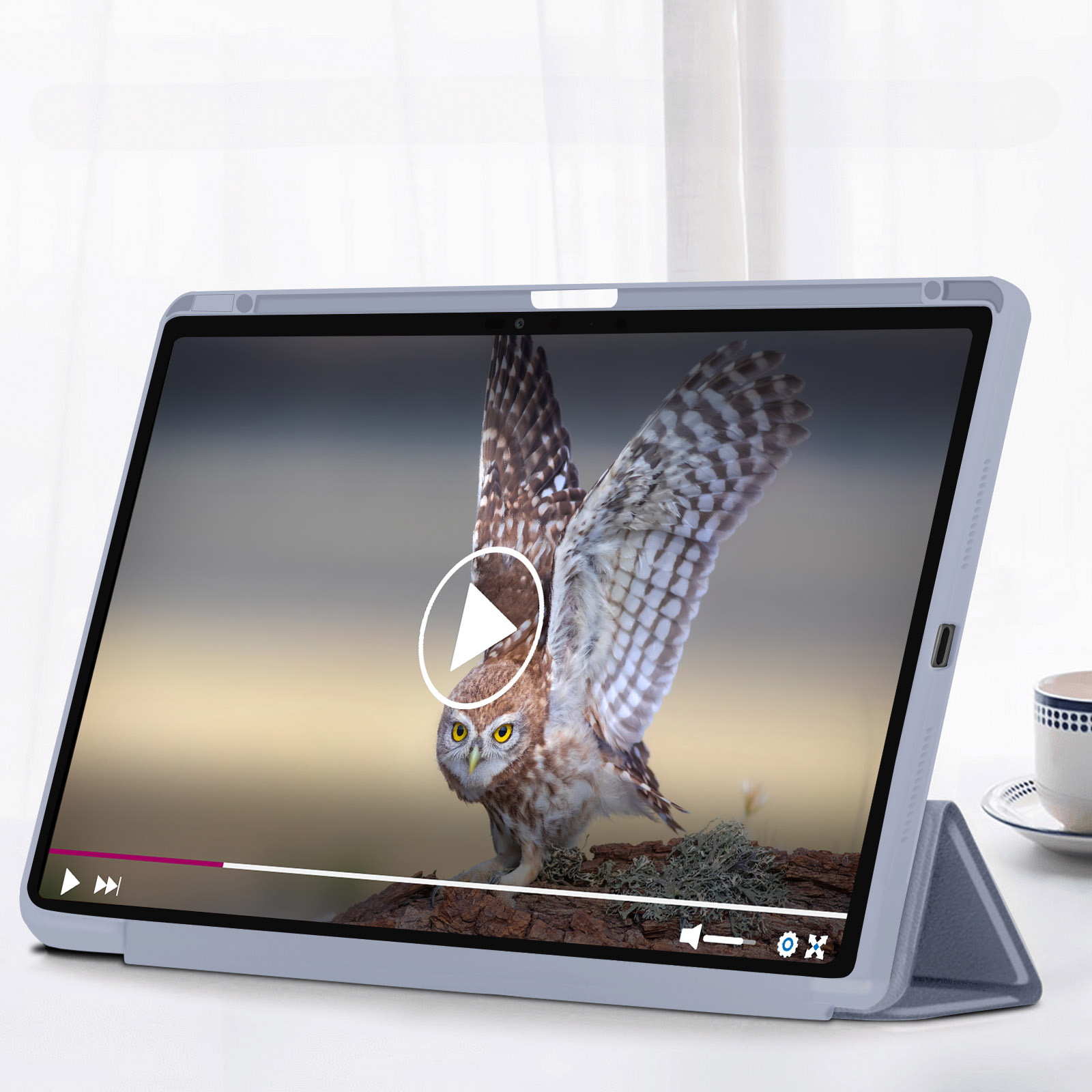 Tablet spielt Video einer Eule ab, weißer Tisch und eine Tasse.