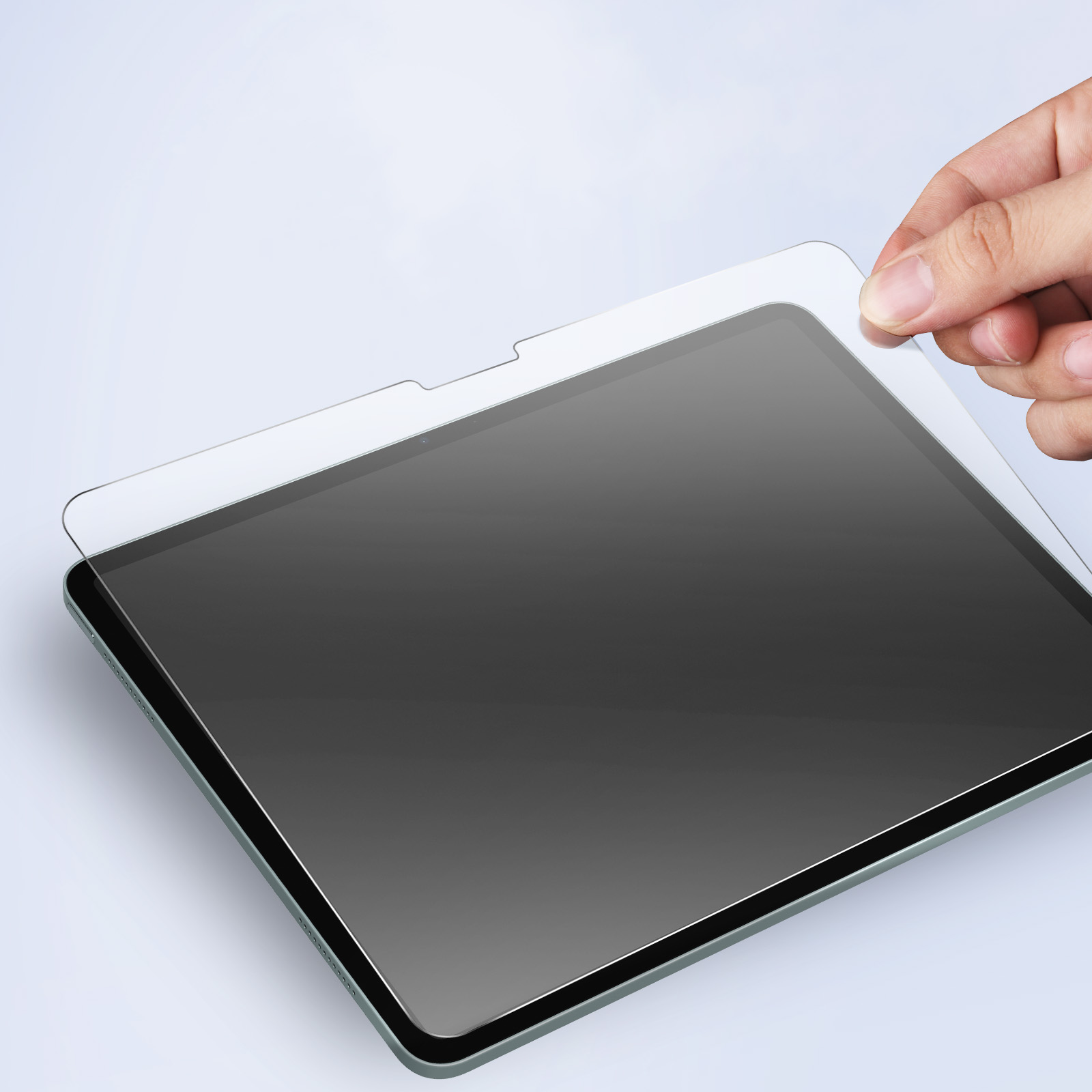 Una mano che posiziona una protezione per lo schermo trasparente su un tablet nero.