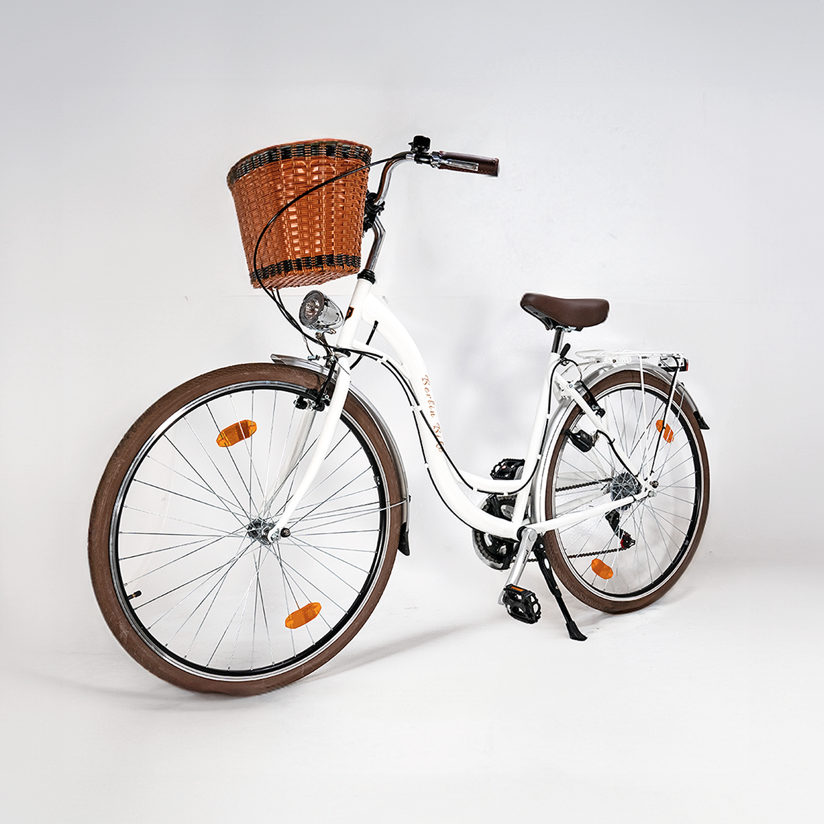 Weißes Fahrrad mit braunen Reifen und einem Korb. Es ist auf weißem Hintergrund.