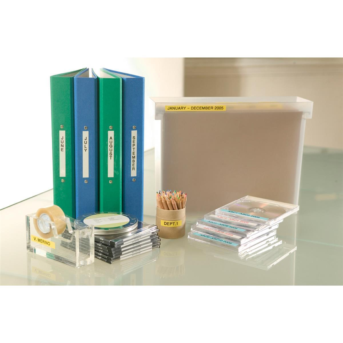 Forniture per ufficio, raccoglitori, CD, matite e un dispenser per nastro adesivo su un tavolo.