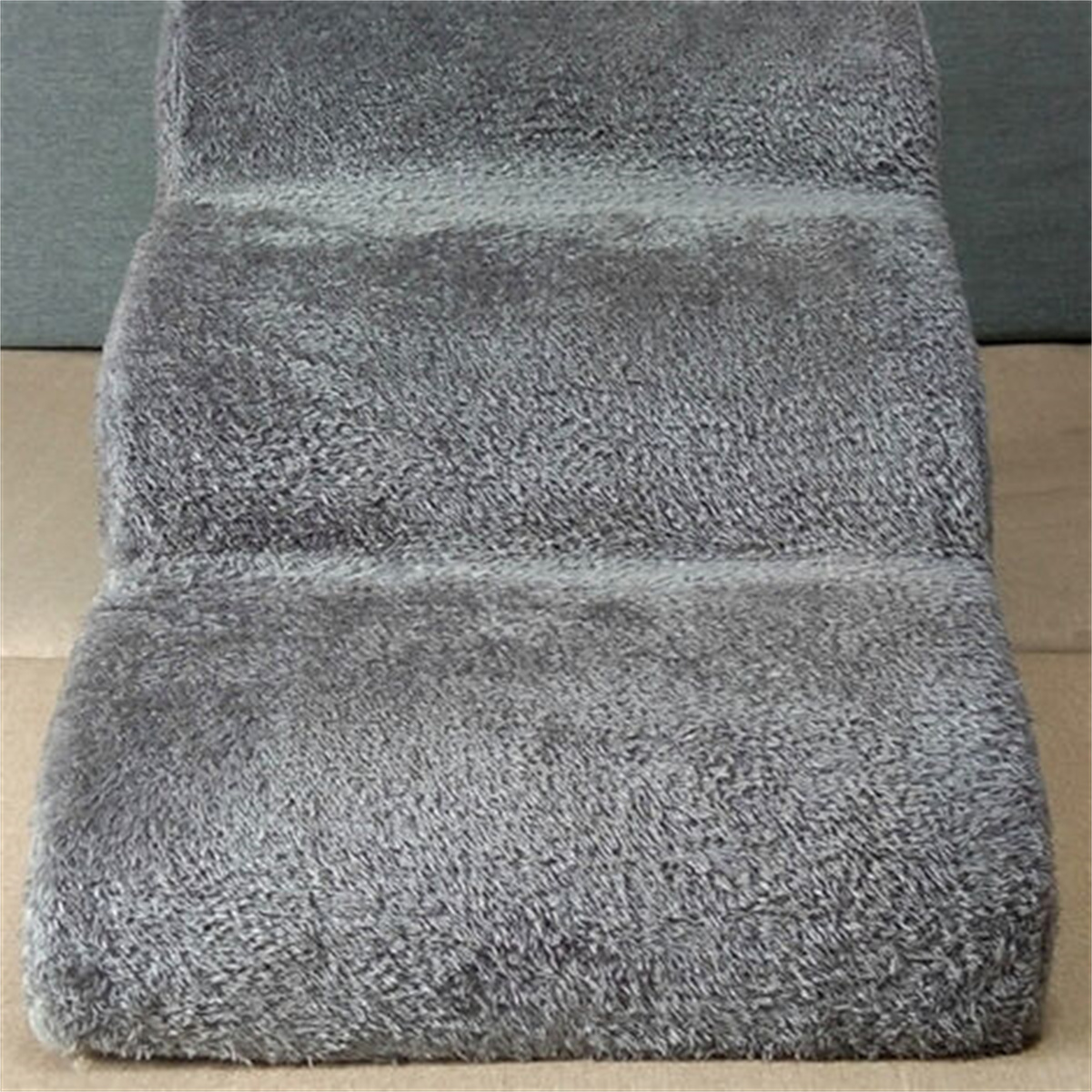 Eine dreistufige Tier-Treppe in Grau. Die Treppe ist mit einem weichen, plüschigen Material bedeckt.