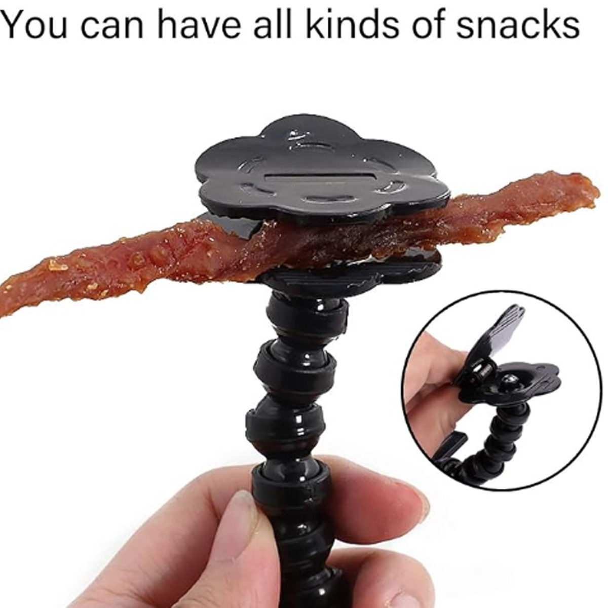 Ein Snack wird von einem schwarzen, flexiblen Arm mit einem blütenförmigen Clip gehalten.