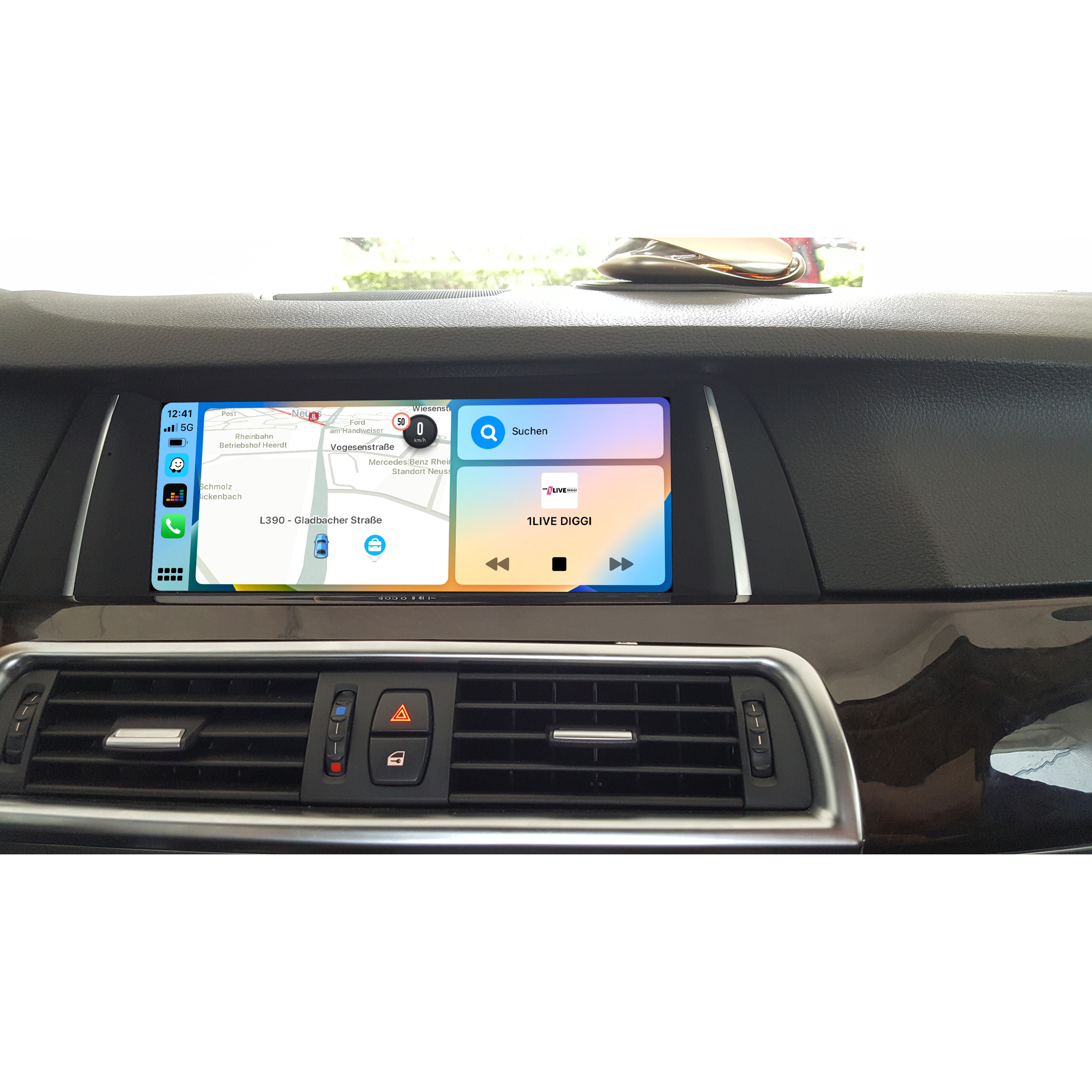 Das Armaturenbrett eines Autos mit einem Navigationsbildschirm, der eine Karte und Medienbedienung zeigt.