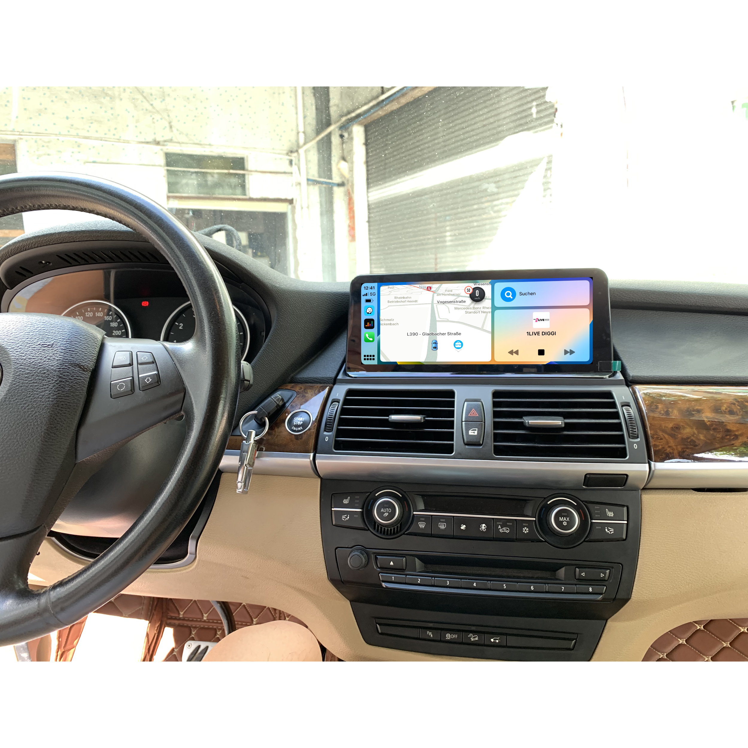 Autoinnenraum mit Navigationsbildschirm auf dem Armaturenbrett. Lenkrad auf der linken Seite. Beige Innenausstattung.