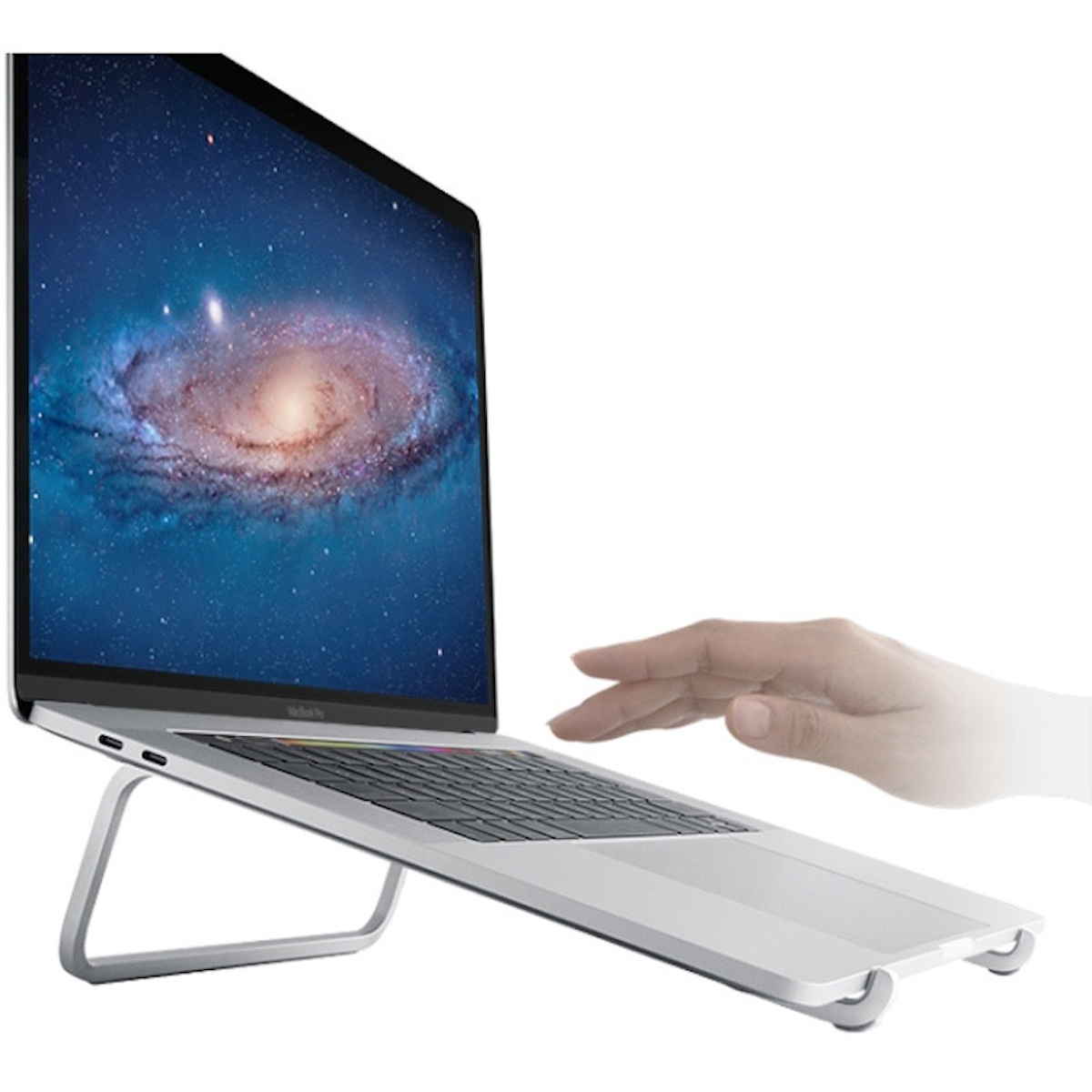 Laptop auf einem Ständer mit Galaxienbildschirm. Eine Hand greift nach dem Bildschirm.