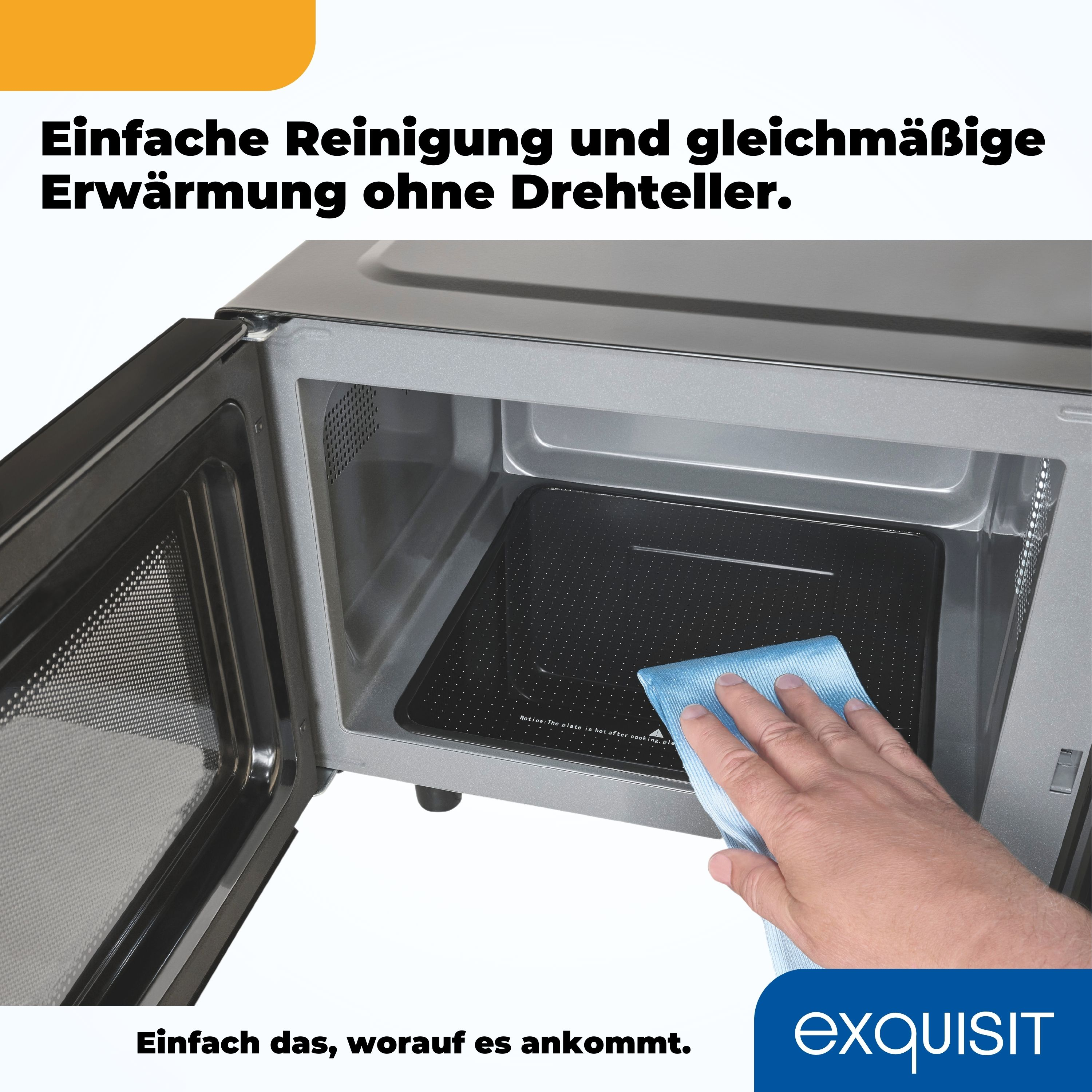 Mikrowelleninnenraum mit Tablett und einer Hand, die es mit einem blauen Tuch abwischt. Text oben links.