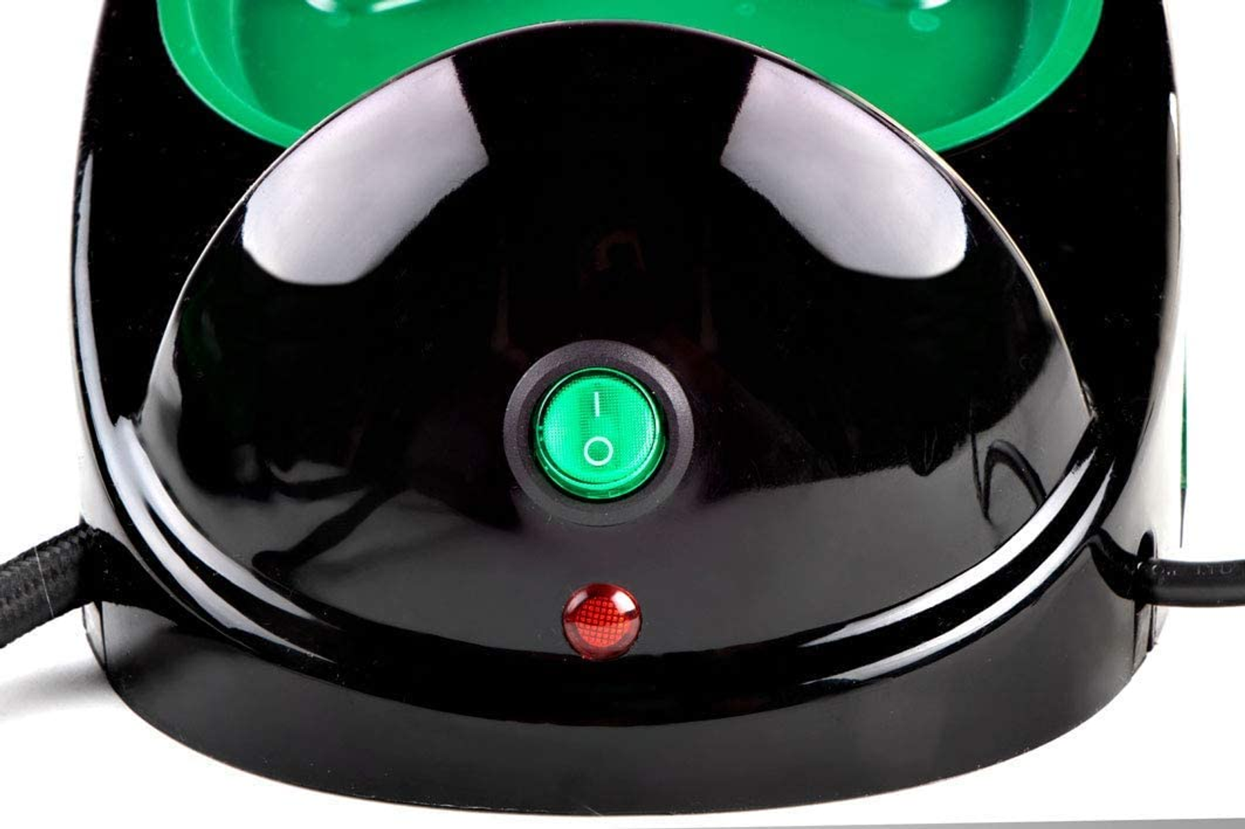 Primer plano de un electrodoméstico negro y verde con botón de encendido verde y luz roja.