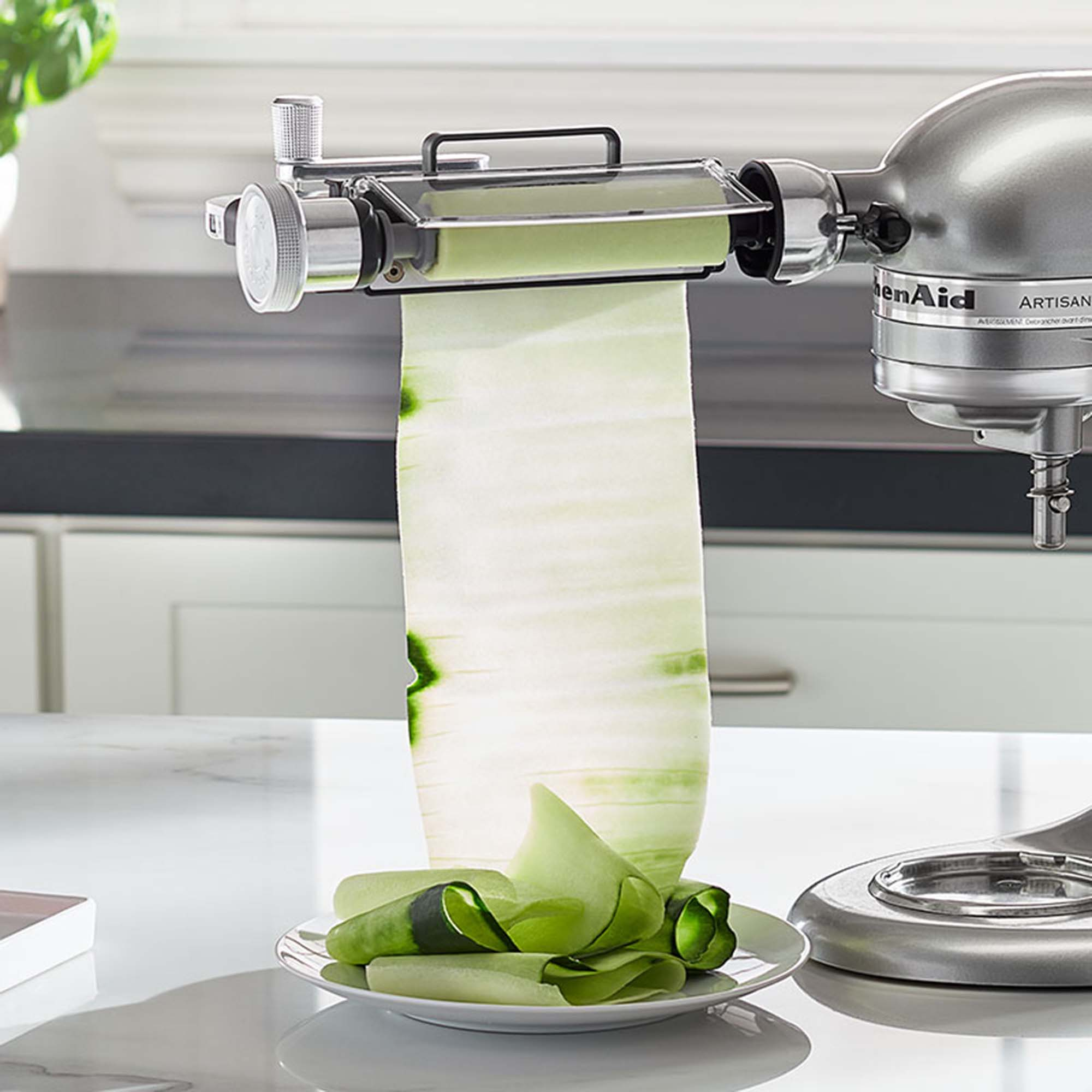 KitchenAid Küchenmaschine mit Gemüse-Spiralschneider. Grüne Gemüsestreifen werden produziert.