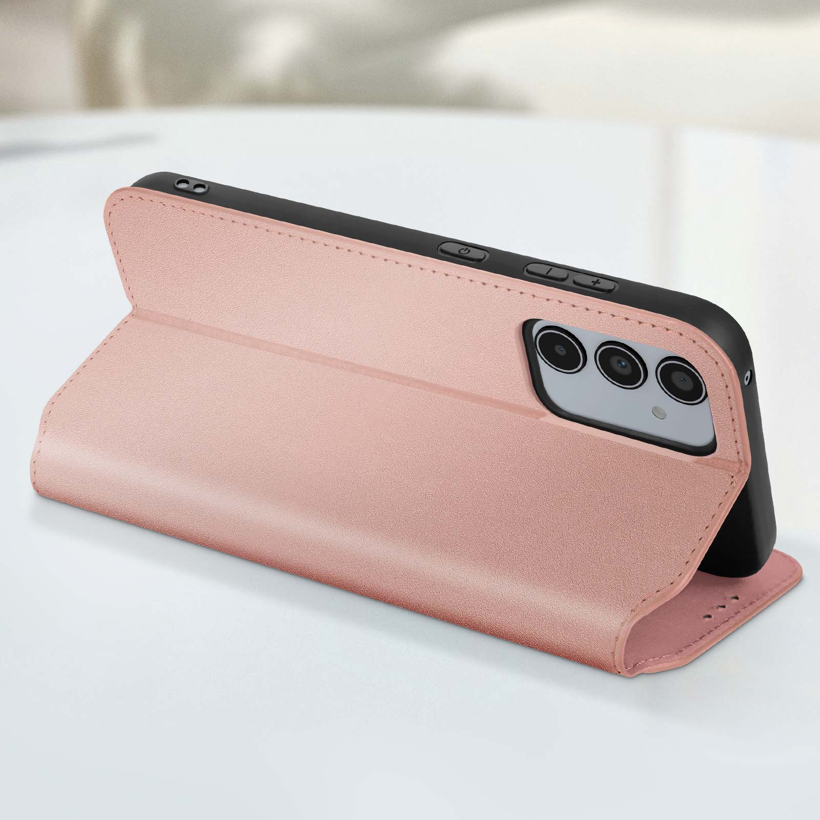 Una custodia per telefono rosa, aperta, che mostra un telefono, su un tavolo.