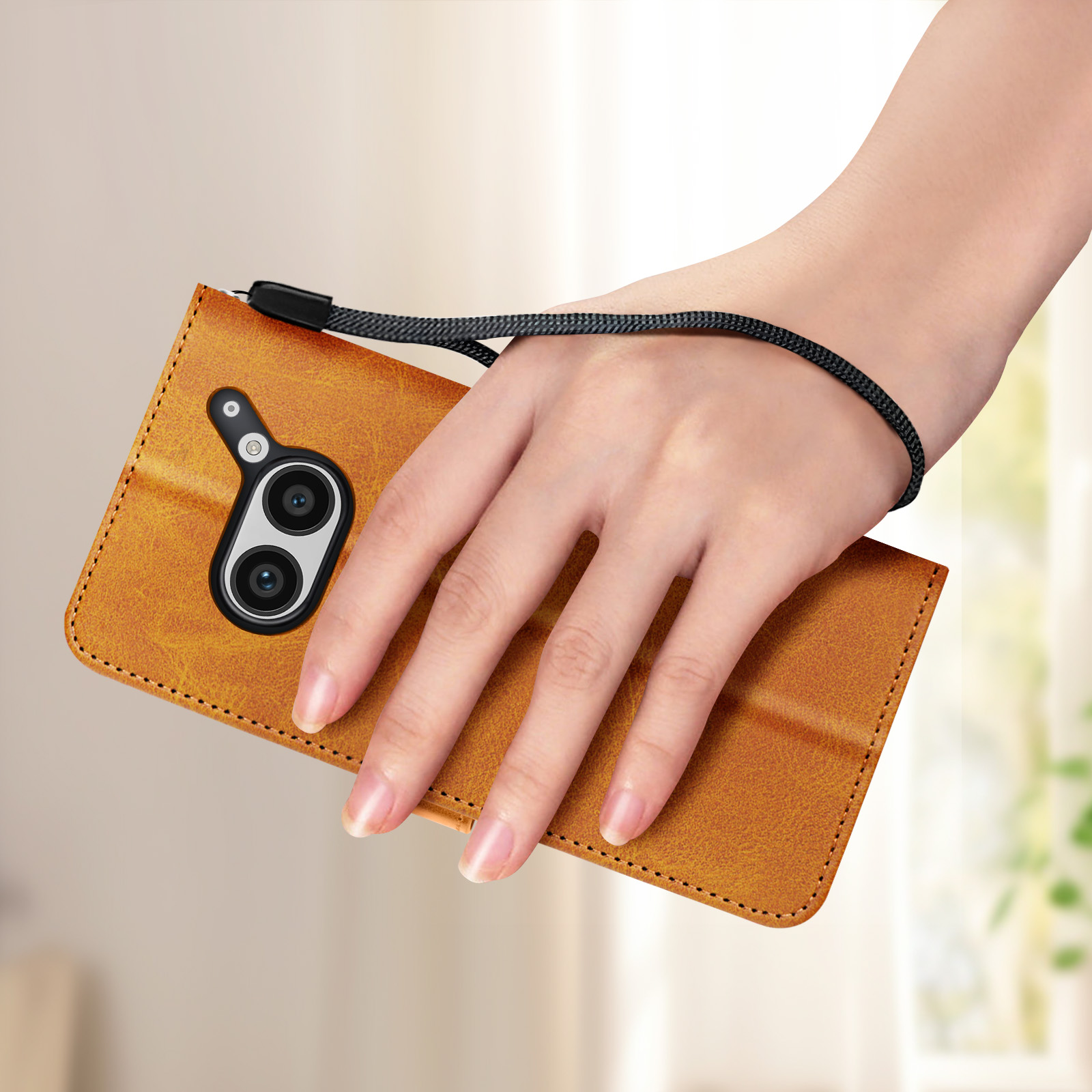 Mano che tiene una custodia per telefono marrone con un telefono all'interno. Presenta una fotocamera e un cinturino da polso.
