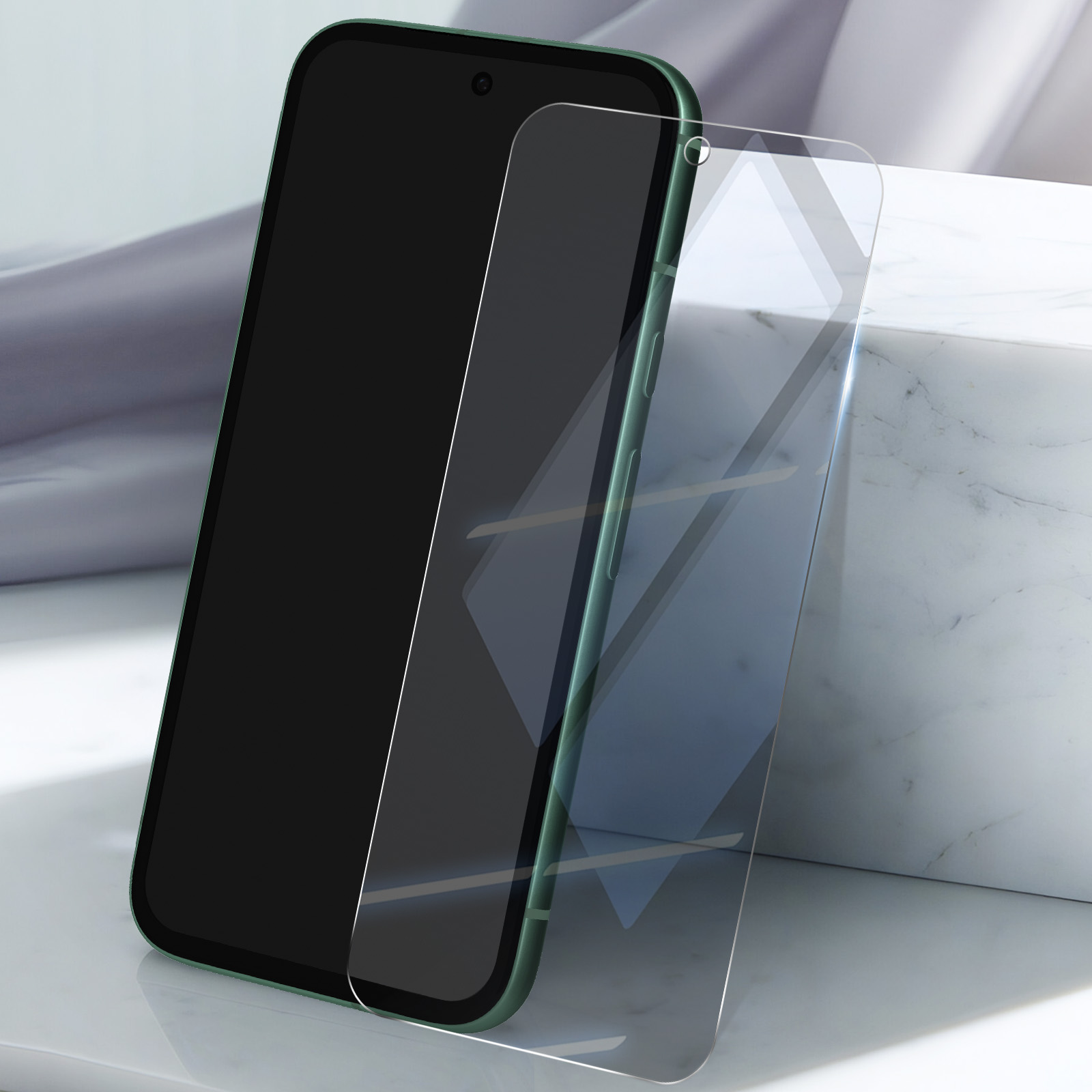 Un telefono verde con una protezione per lo schermo in fase di installazione, su una superficie bianca.