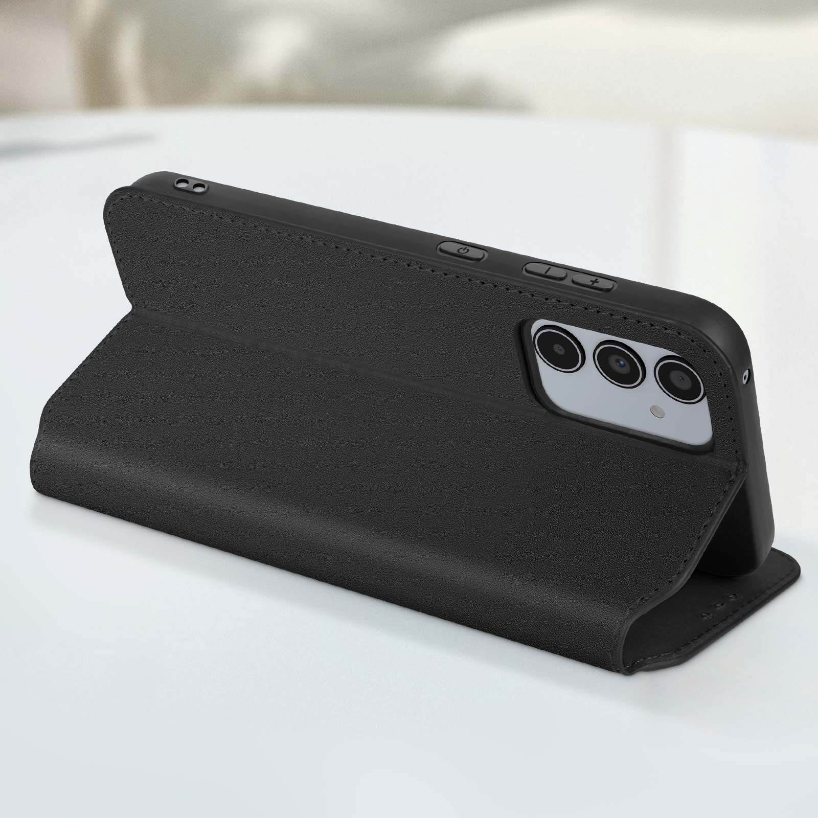 Una custodia nera per telefono è aperta, sostenendo un telefono. Il telefono ha tre fotocamere.