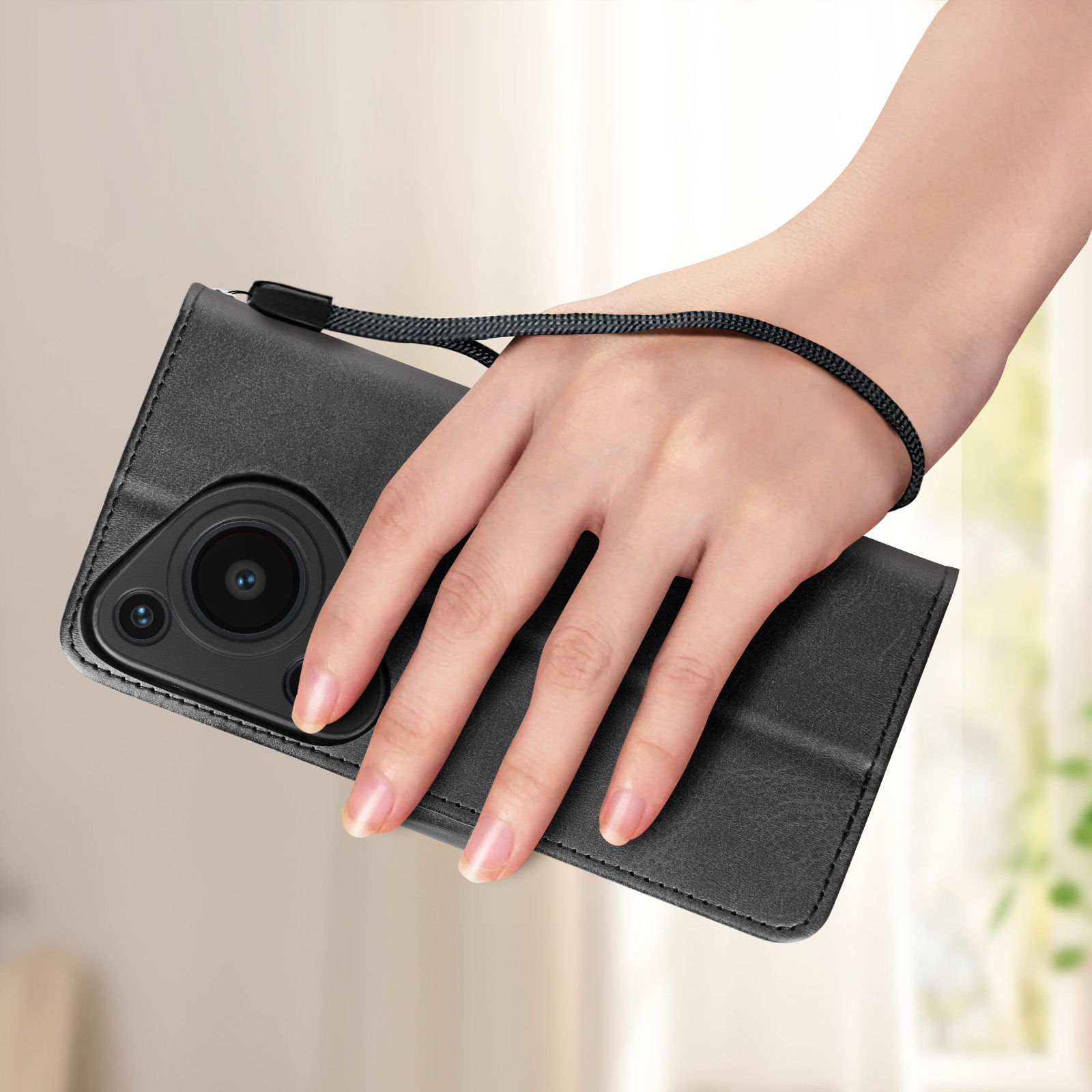 Custodia per telefono nera con cinturino tenuta da una mano, fotocamera visibile.