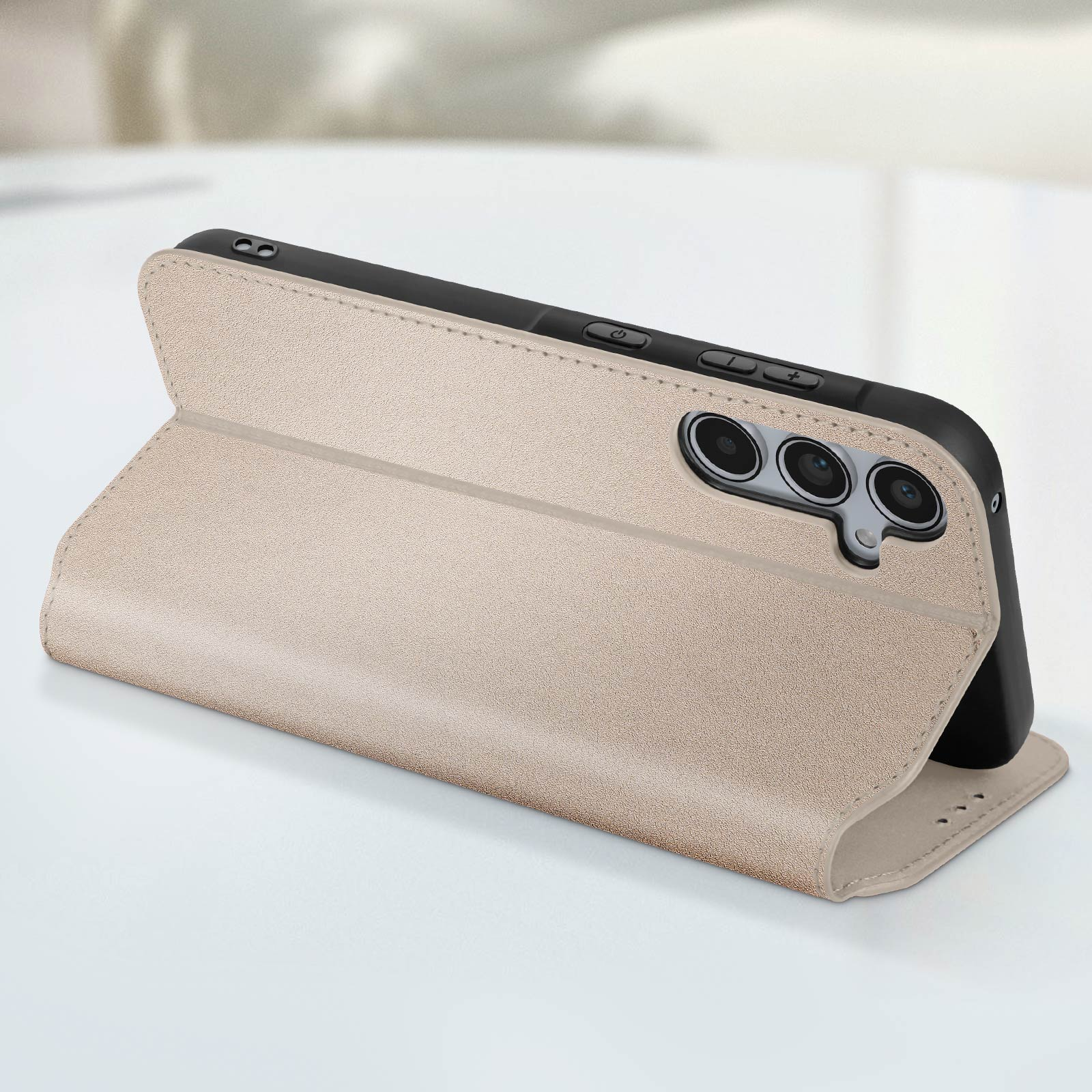 Custodia del telefono beige aperta su una superficie bianca. Un telefono nero è all'interno. Il telefono ha una fotocamera.