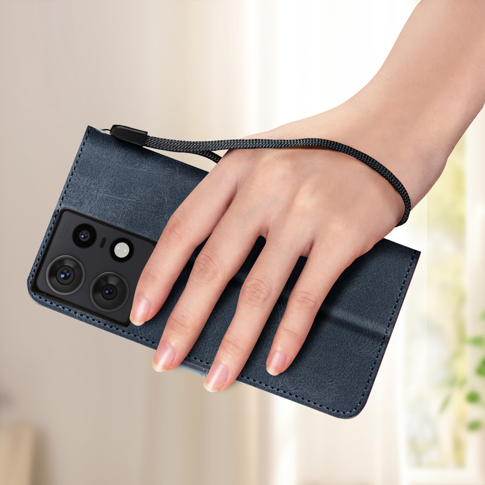 Una mano che tiene un telefono blu con custodia e cinturino. Il telefono ha più obiettivi.