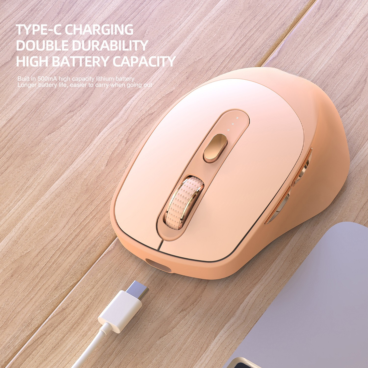 Eine pfirsichfarbene kabellose Maus mit einem Scrollrad und einem USB-C-Kabel auf einer Holzoberfläche.