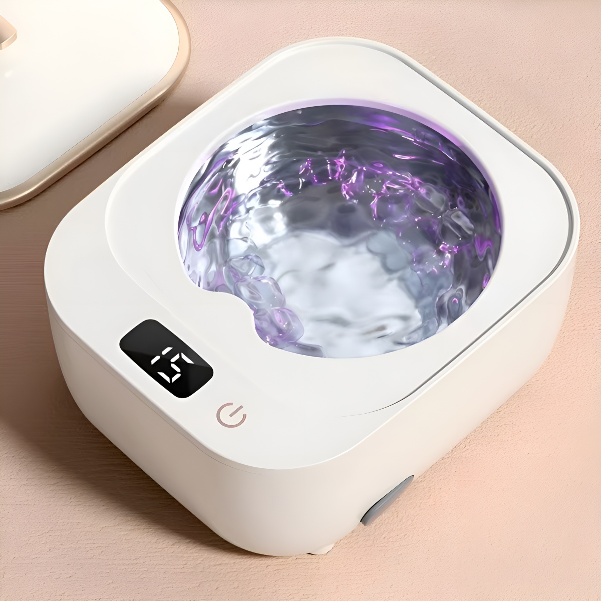 Weißer Zahnreiniger mit lila Flüssigkeit. Zeigt eine digitale Temperaturanzeige und einen Ein-/Ausschalter. Draufsicht.