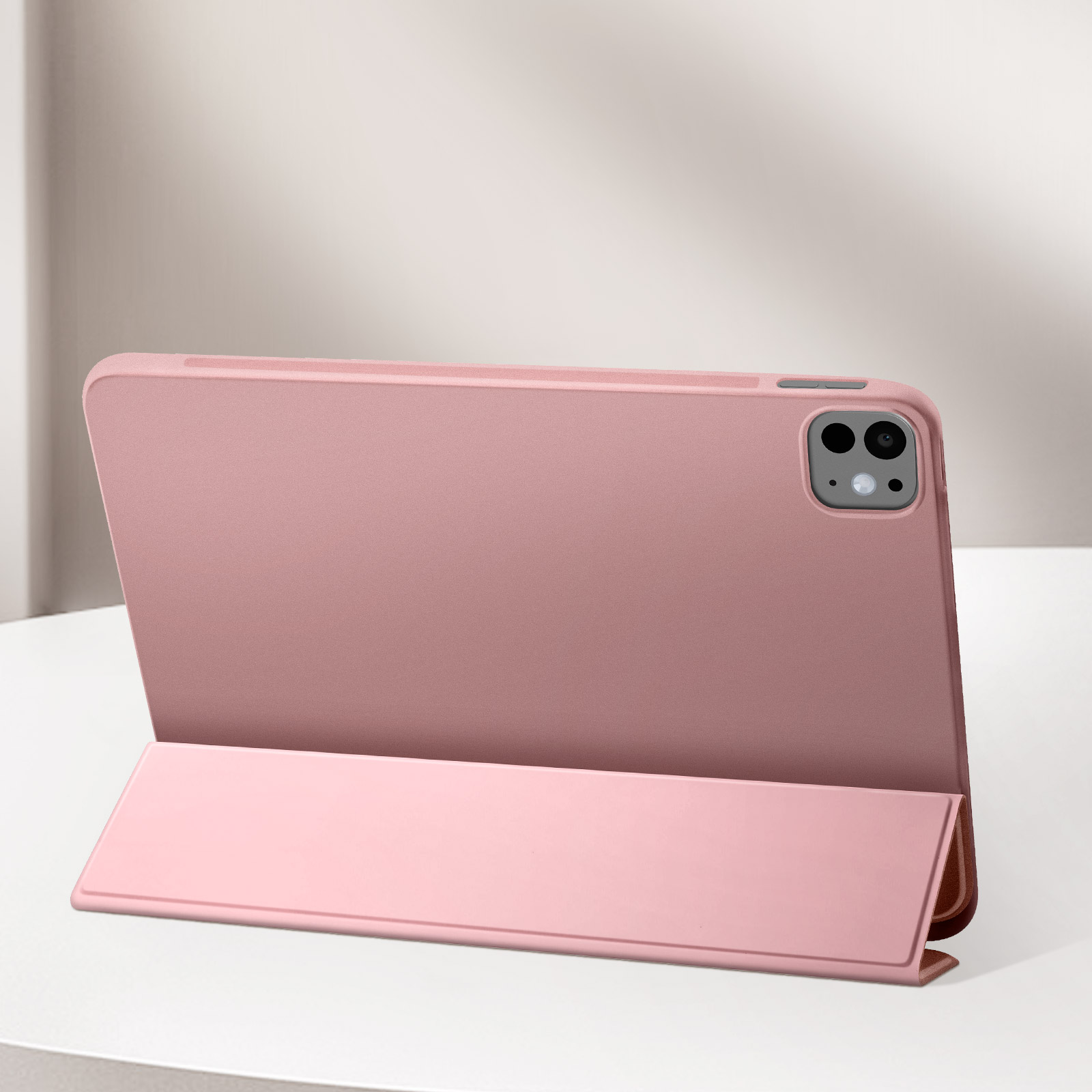 Una custodia rosa per tablet è aperta. Il tablet è all'interno della custodia. Sfondo bianco. La fotocamera è visibile.