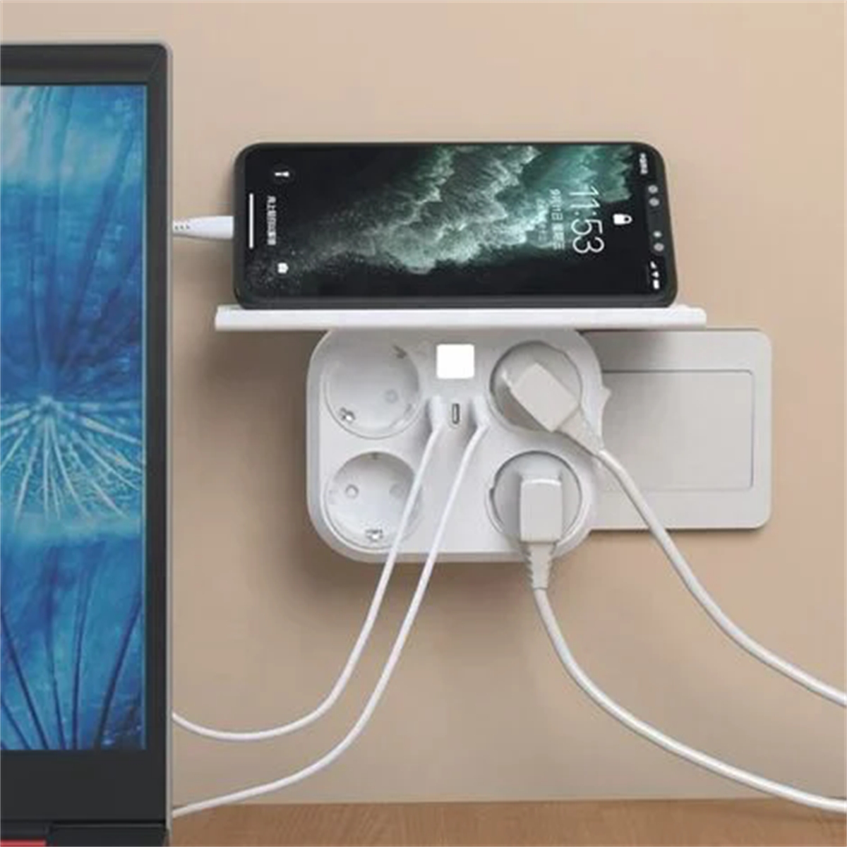 Weiße Steckdosenleiste mit Telefonladung, Telefon oben und mehrere Stecker, alles an einer beige Wand.