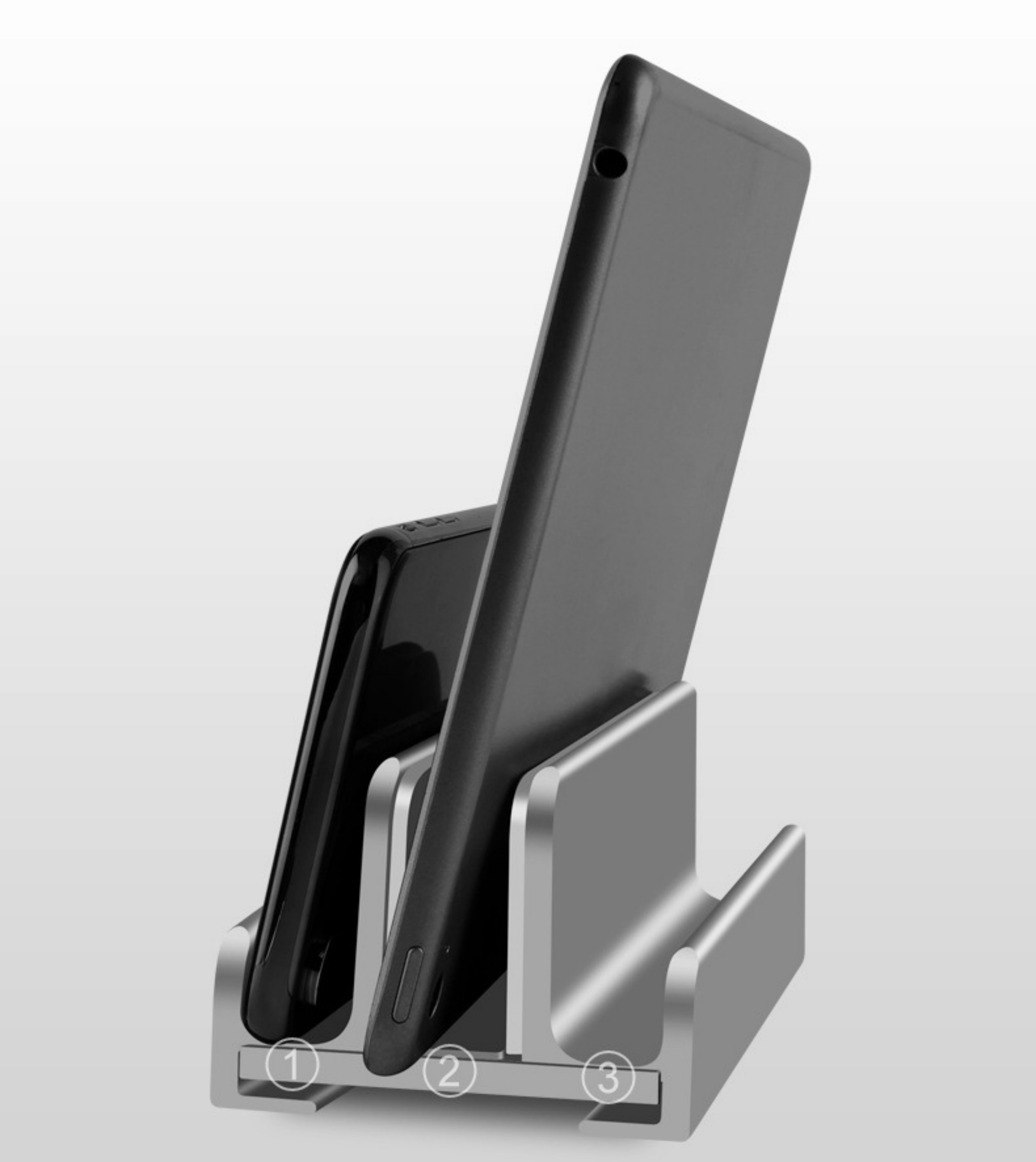 Silberner Telefon-/Tablet-Ständer mit drei Schlitzen. Ein Telefon und ein Tablet befinden sich im Ständer.