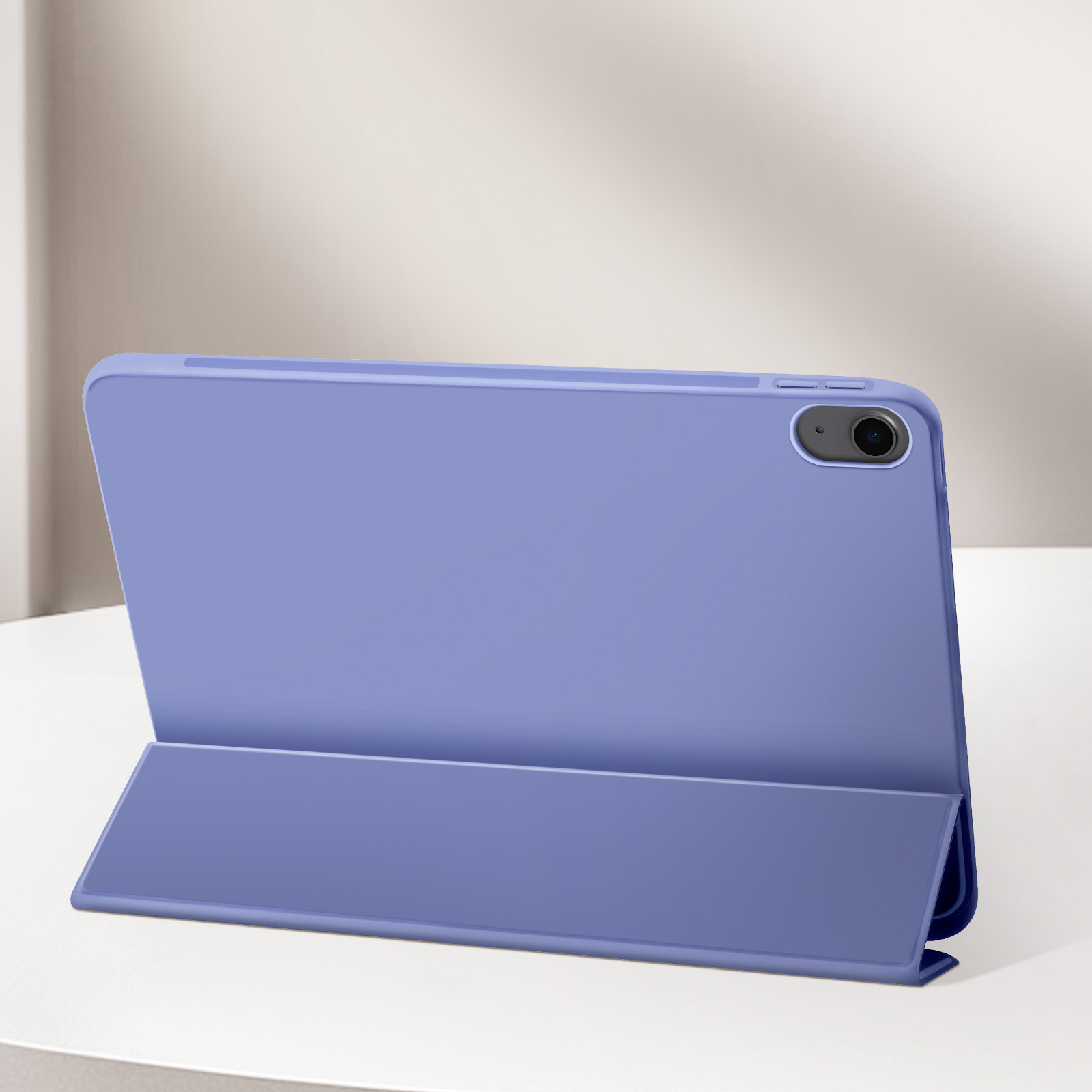 Una custodia blu per tablet, aperta, su una superficie bianca. Lo sfondo è sfocato e chiaro.