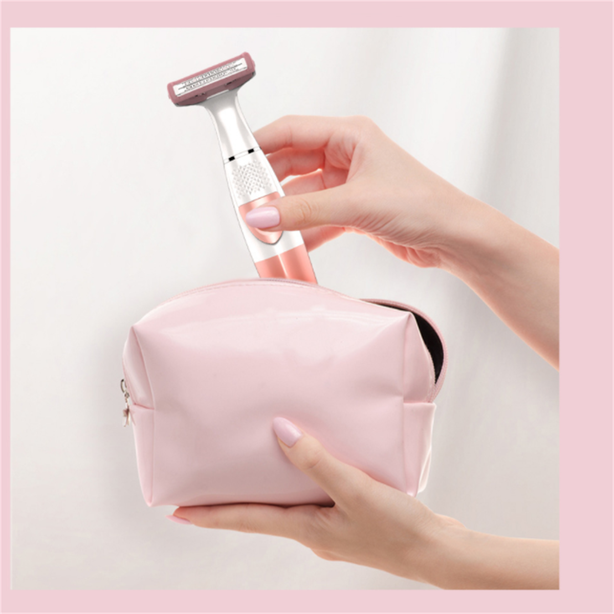 Eine Hand legt einen rosa Rasierer in eine rosa Kosmetiktasche auf rosa Hintergrund.