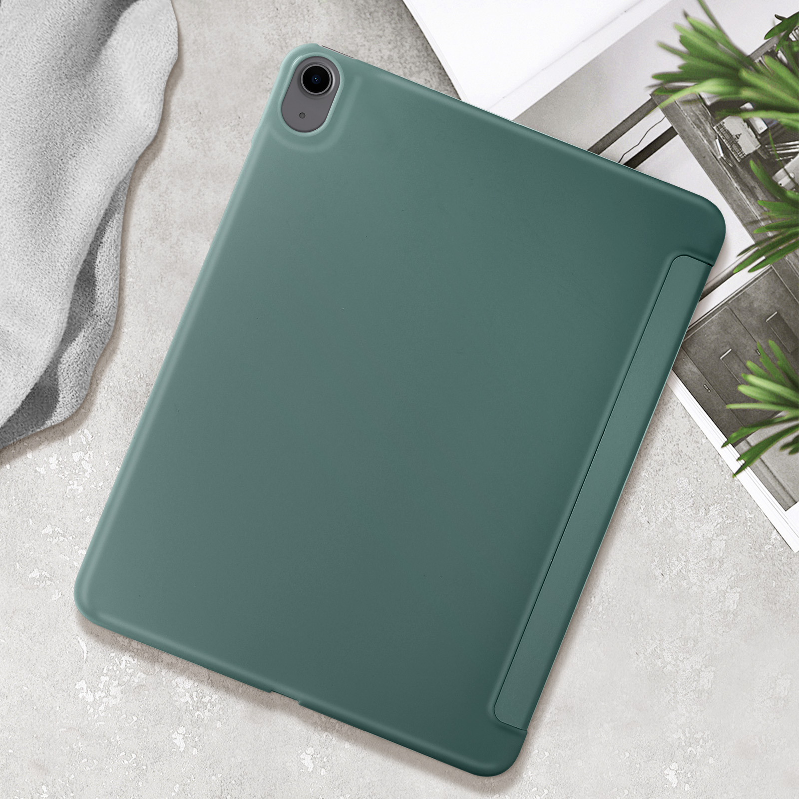 Una custodia verde per tablet su una superficie bianca. La custodia è leggermente aperta, rivelando il bordo del tablet.