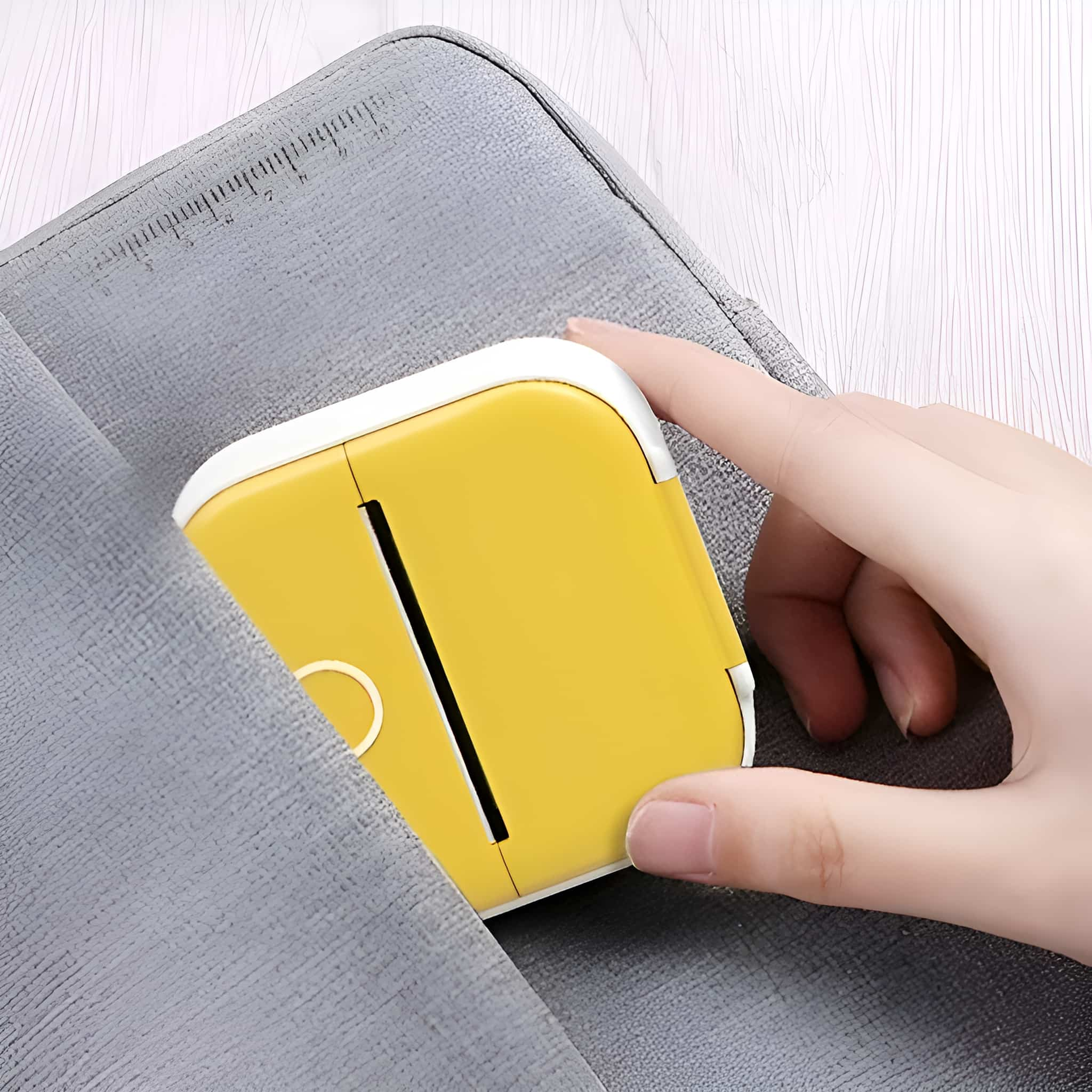 Gelber Drucker in einer Tasche, mit einer Hand, die ihn hält, weißer Hintergrund.