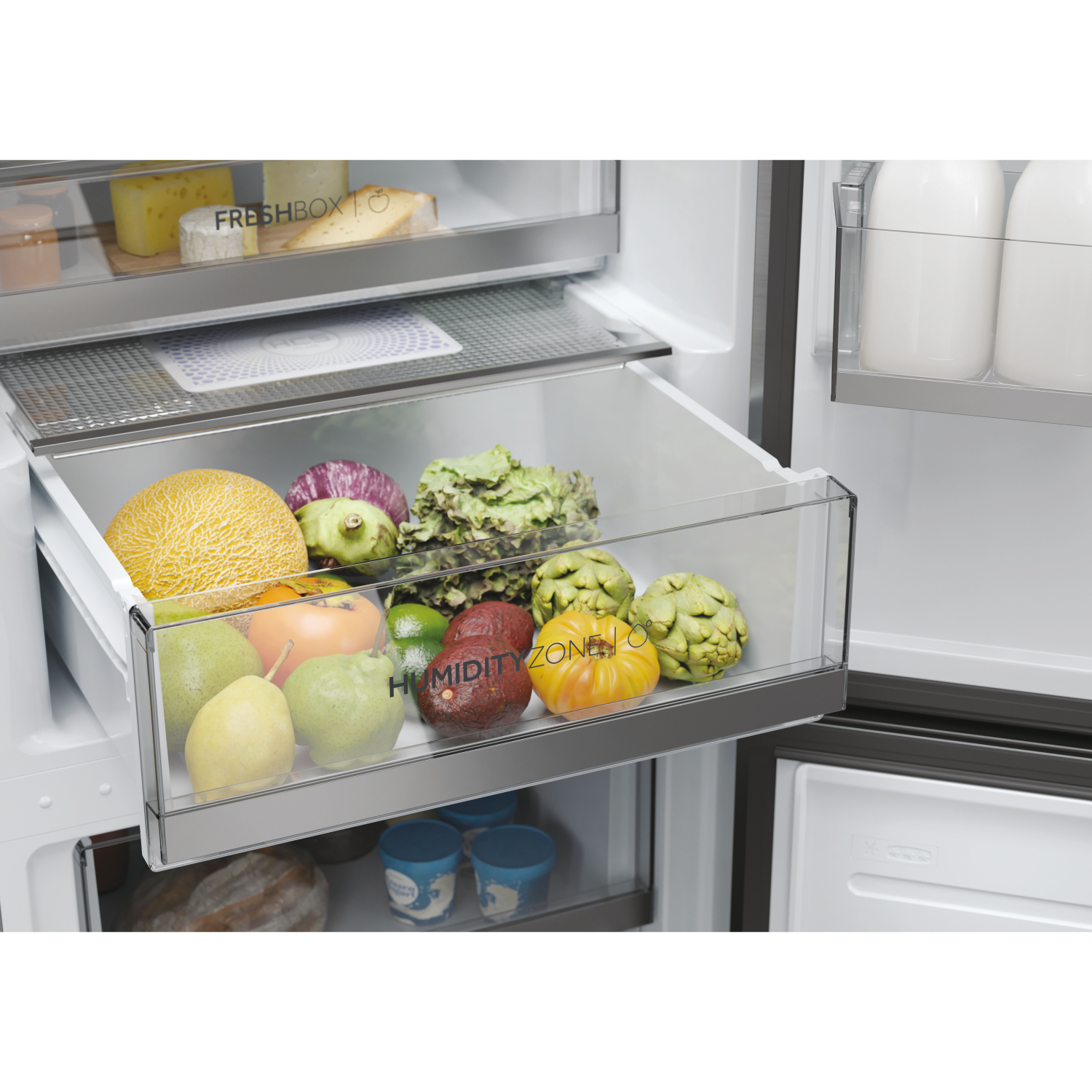 Kühlschublade mit Obst und Gemüse: Melone, Artischocken, Birnen und Salat.