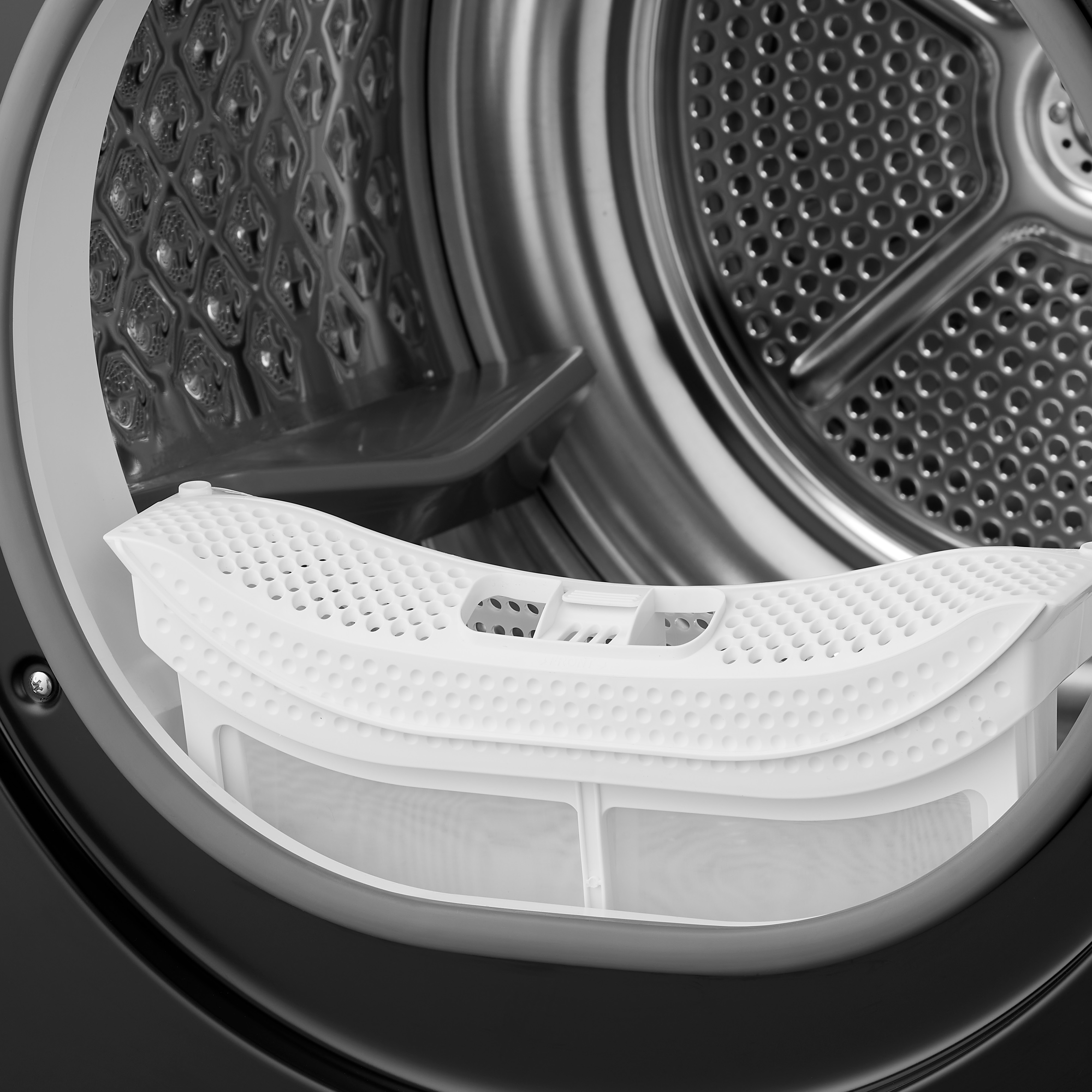 Close up of a white dryer filter inside a black dryer, showing the filter's design.