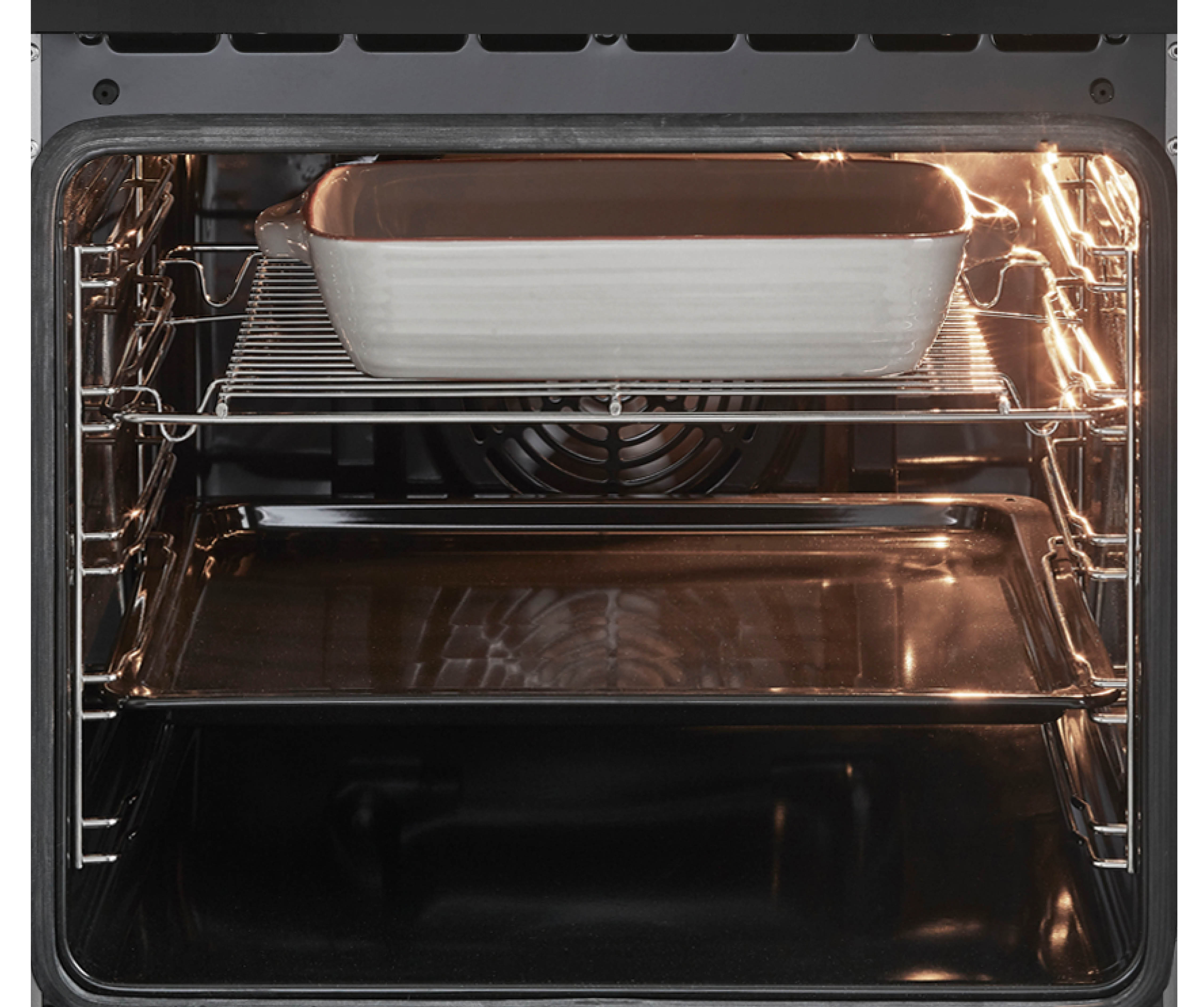 In een oven, een ovenschaal op een rooster en een bakplaat onderin.