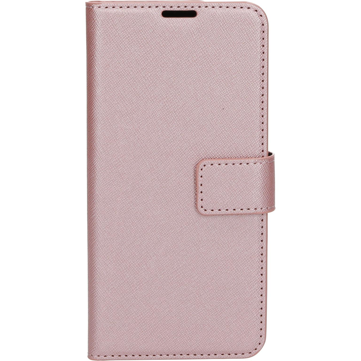 Roze telefoonhoes gesloten. Magnetische sluiting. Heeft een gestructureerd oppervlak.