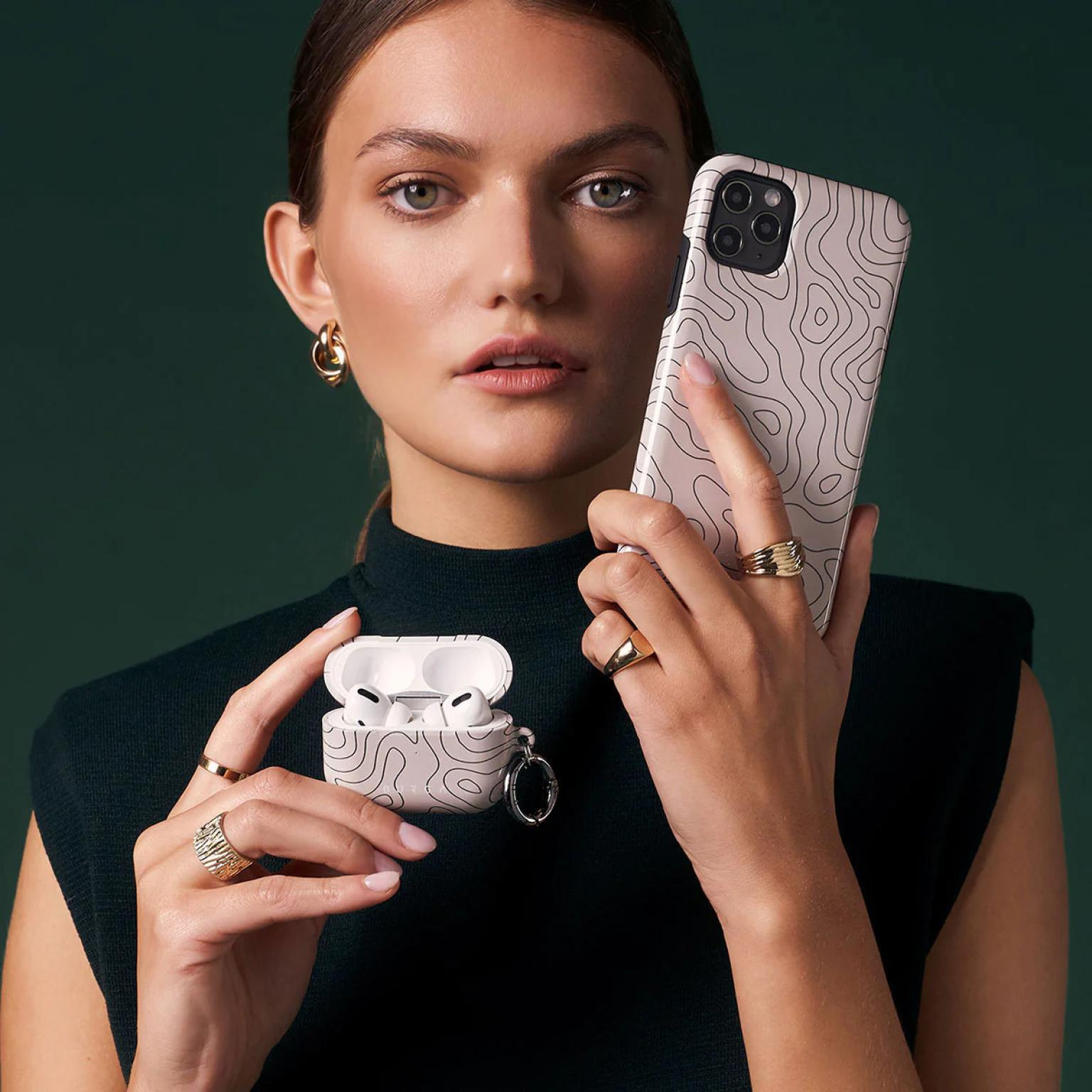 Vrouw met telefoonhoesje en airpods case met topografisch kaart ontwerp.