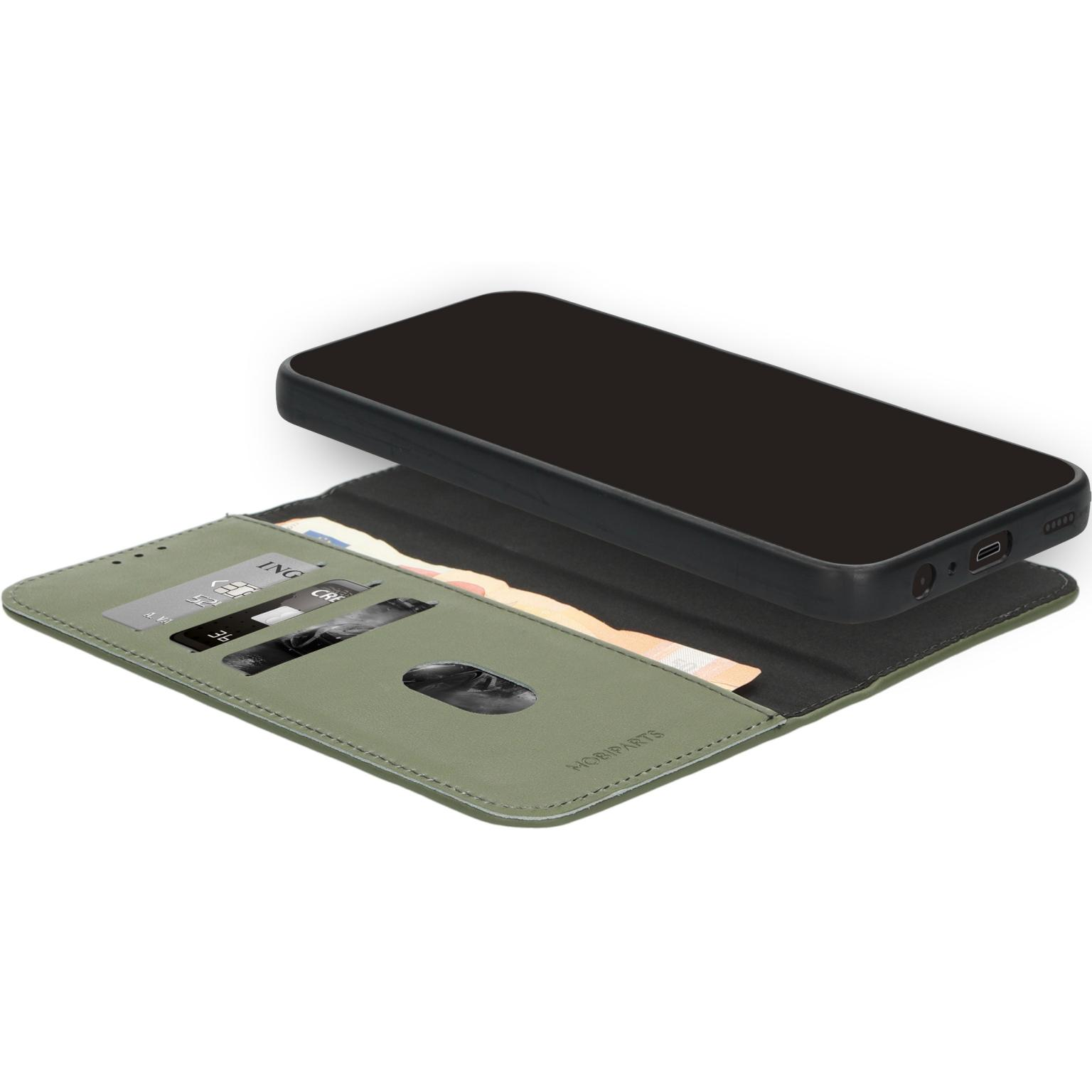Een zwarte telefoon ligt open op een groene portefeuillehoes. Creditcards en contanten zijn zichtbaar in de hoes.