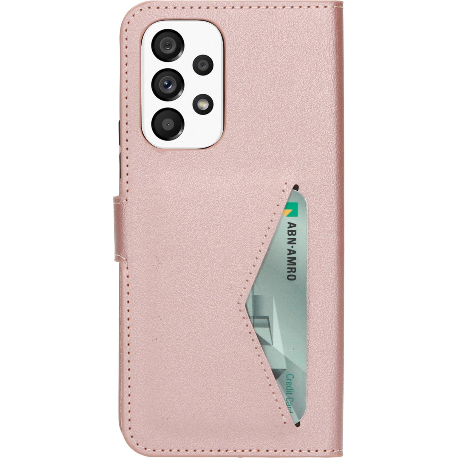 Roze telefoonhoes, met een creditcard in een sleuf. Telefoon heeft meerdere camera's.