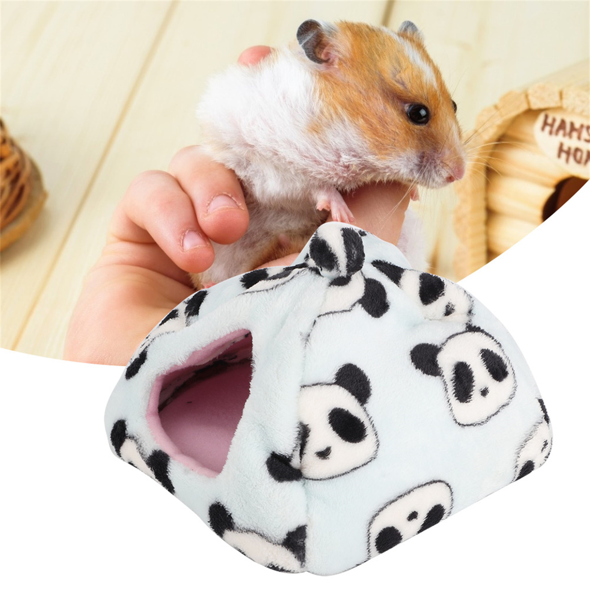 Hamster in der Hand neben einem Hamsterhaus im Panda-Design.