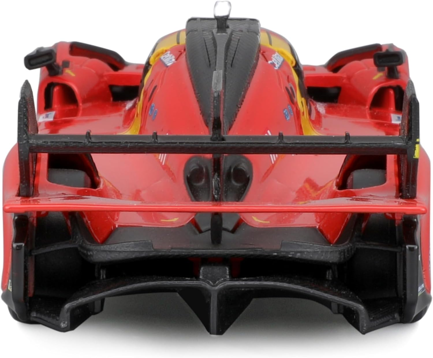 Widok z tyłu czerwonego zabawkowego samochodu wyścigowego. Posiada spojler i rury wydechowe, z czarnym i karbonowym wzorem.