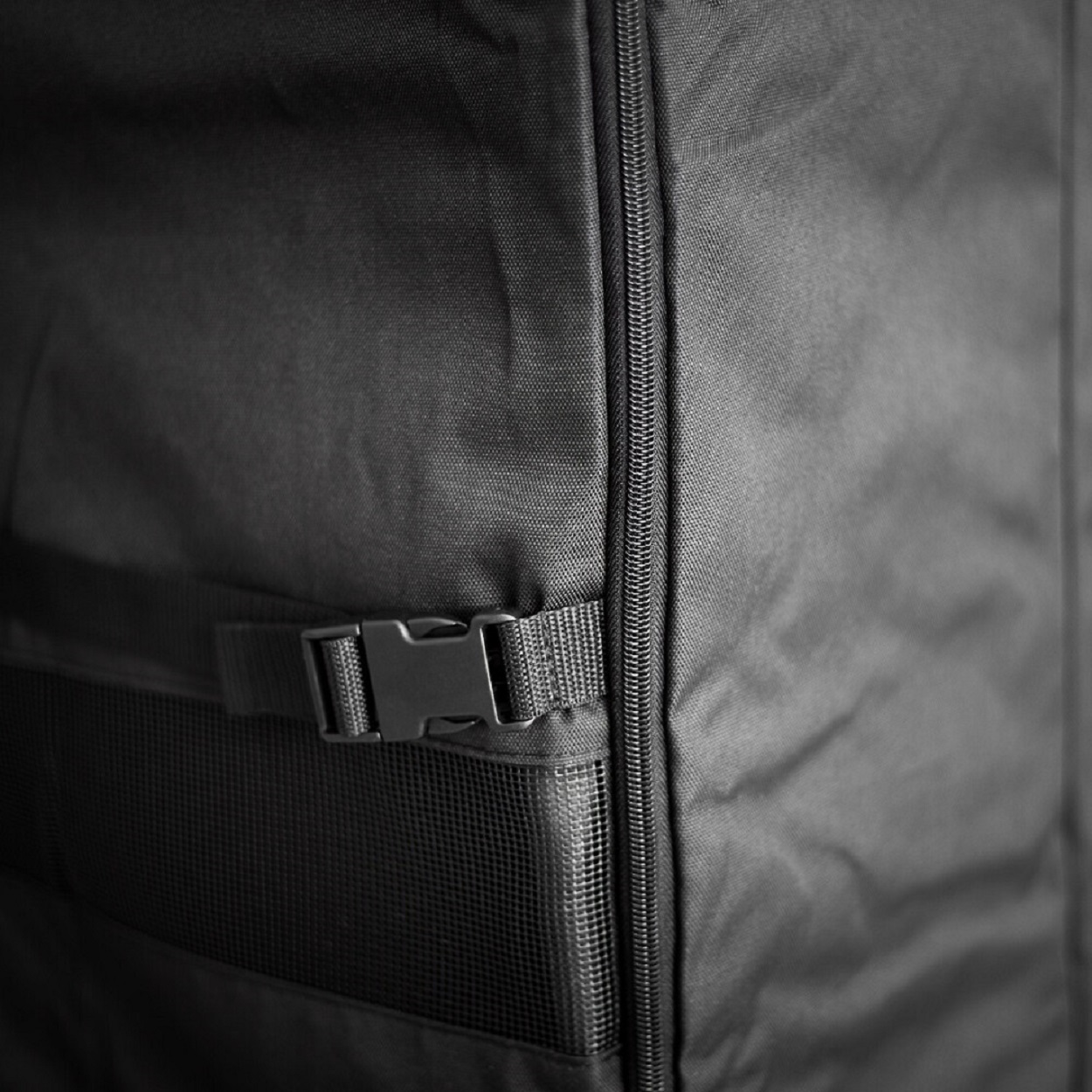 Nahaufnahme einer schwarzen Tasche mit Reißverschluss und Schnallenriemen.